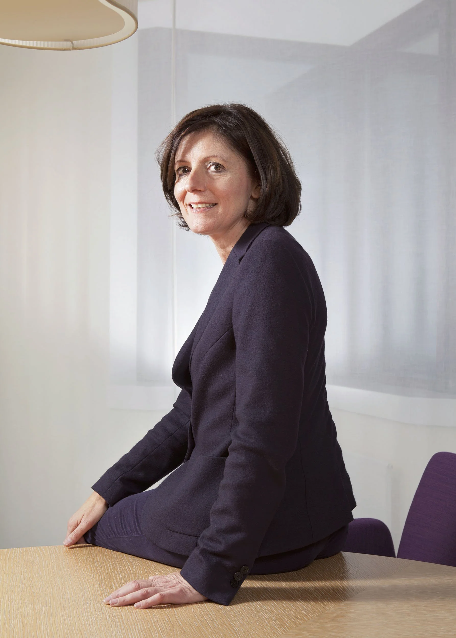 Malu Dreyer (Ministerpräsidentin a.D.) sitzt auf einer Tischkante und schaut in die Kamera für das Cicero Magazin: Editorial Portrait von Angelika Zinzow