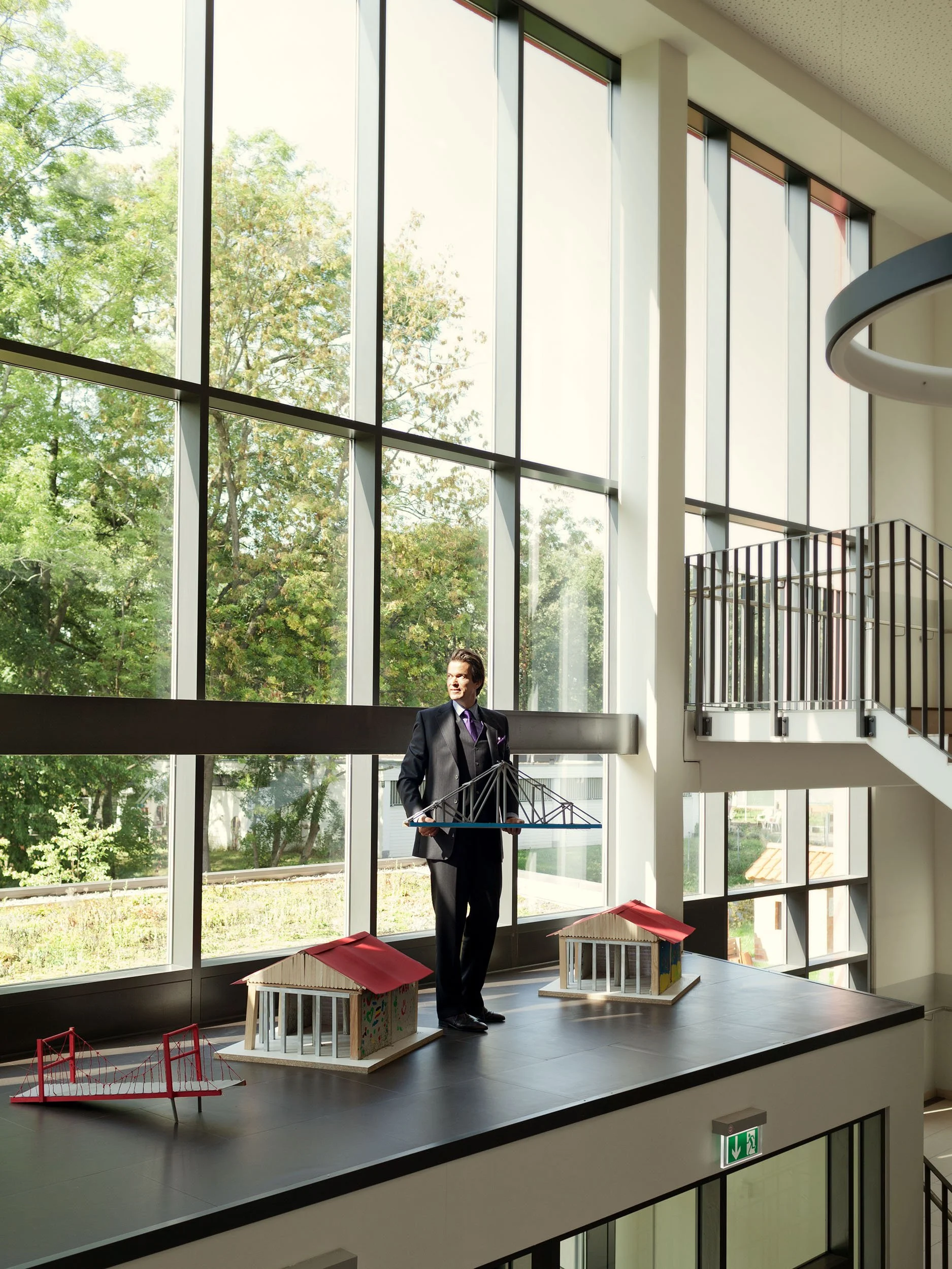 Unternehmer Christian Boehringer vor einer Fensterfront mit einem Brückenmodel in der Hand (Boehringer Ingelheim): Management Portrait von Angelika Zinzow