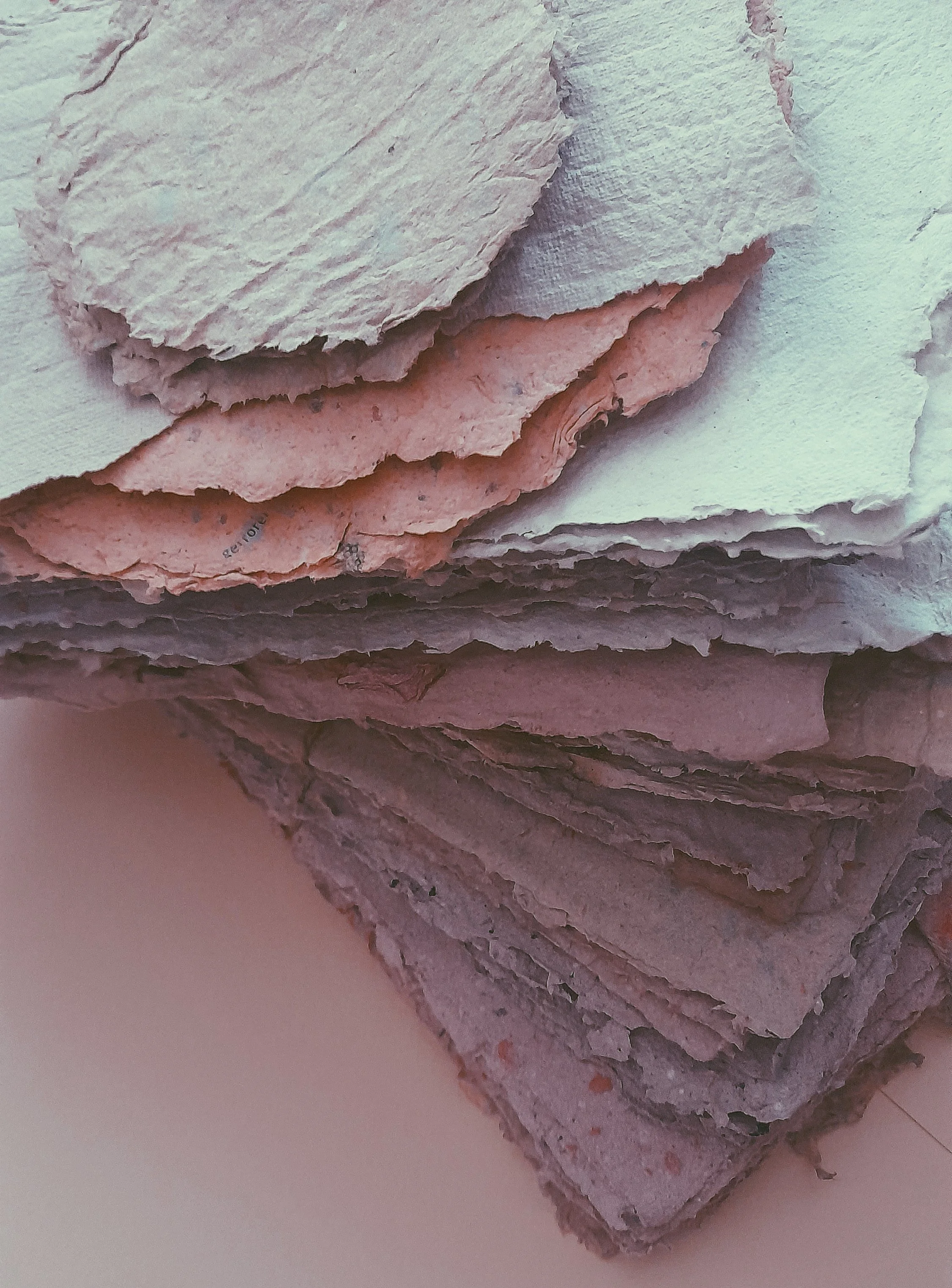 Haufen von zerknittertem handgemachtem Papier in unterschiedlichen Farben und Texturen.