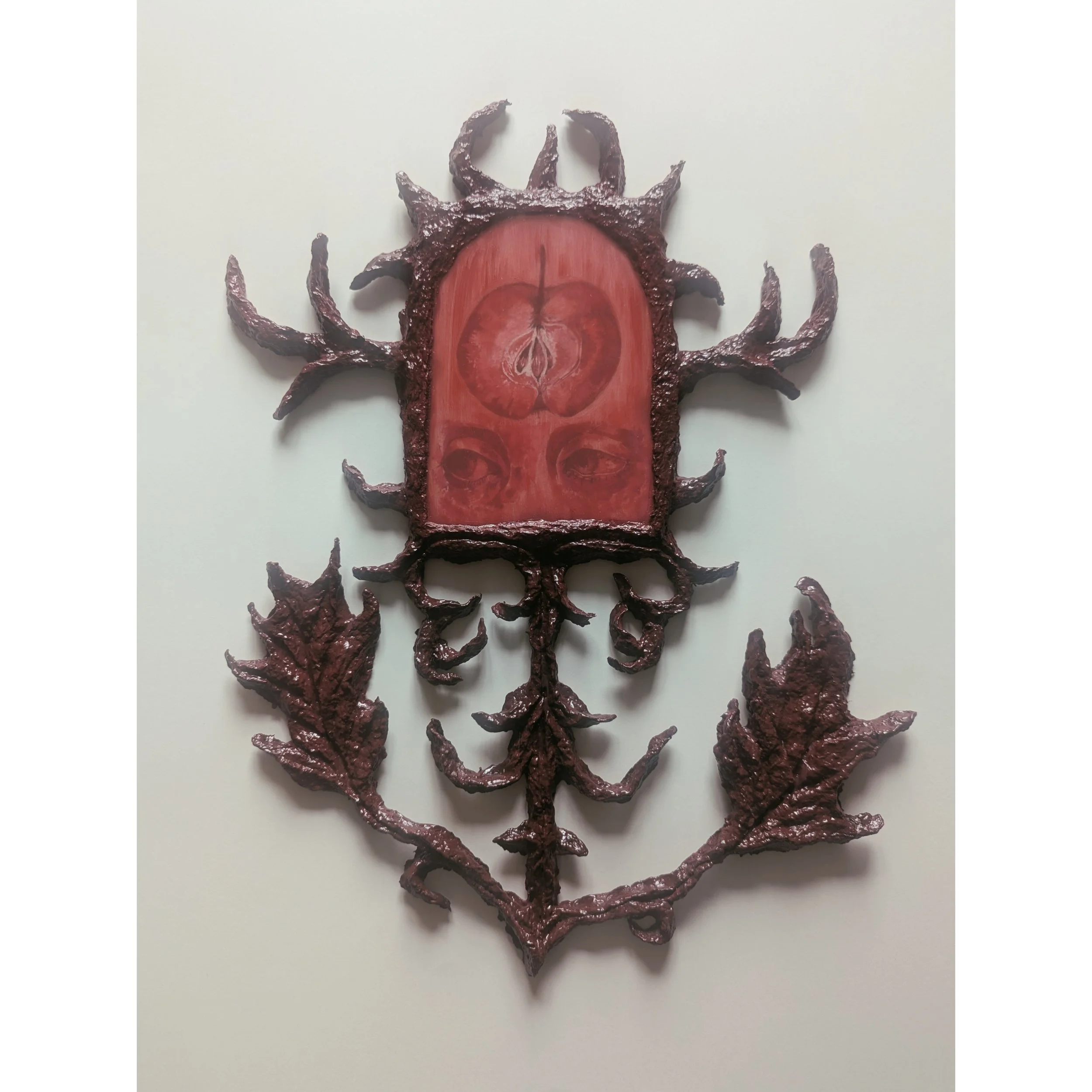 Ein Kunstwerk, das eine Kreatur mit einem roten, an eine Frucht erinnernden Körper und einer schwarzen, hornartigen Struktur auf dem Kopf darstellt, umgeben von schwarzen, wurmartigen Anhängseln auf weißem Hintergrund.