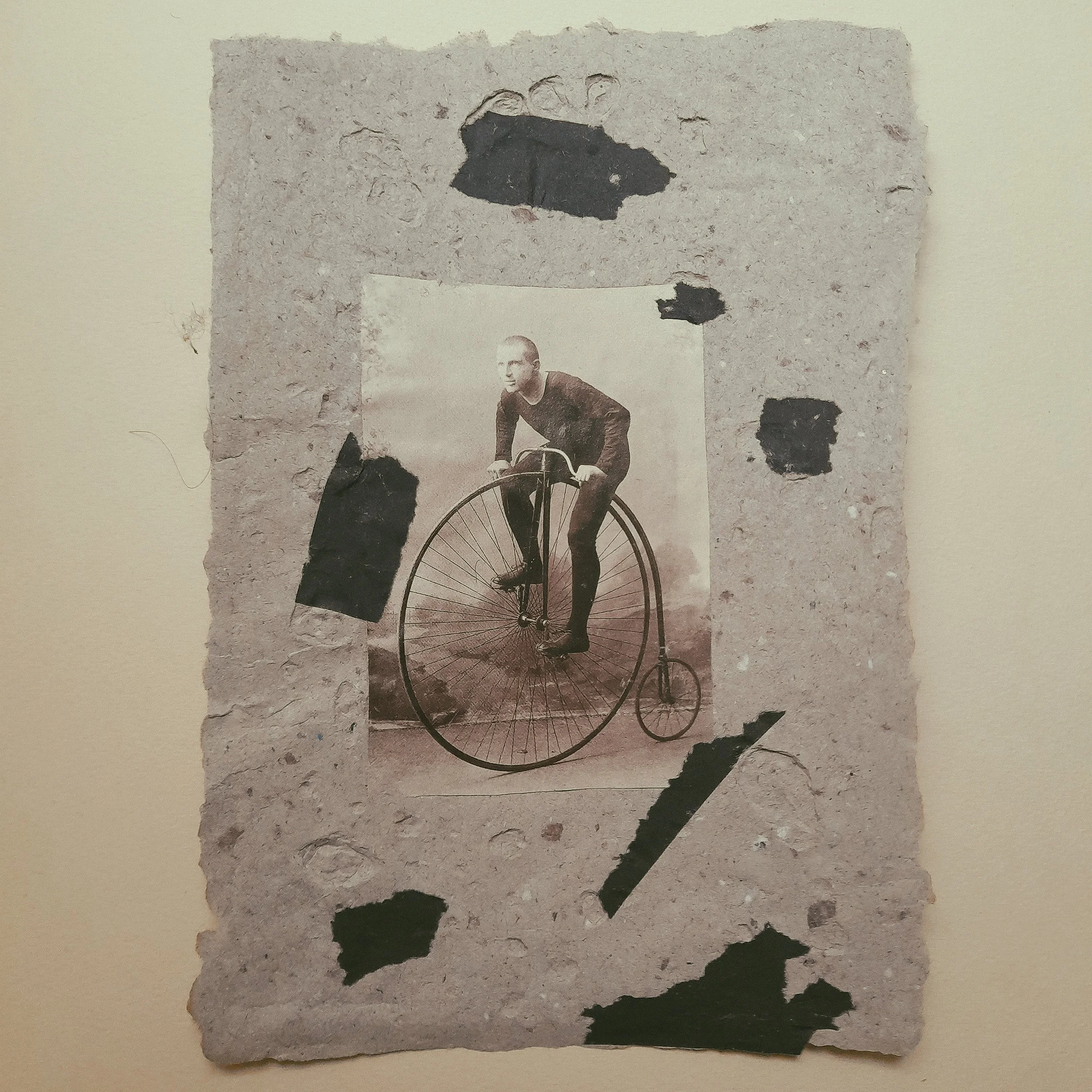 Schwarz-Weiß-Foto eines Mannes, der auf einem Großrad fährt, als Collage auf einer zerzausten, perforierten Pappe.
