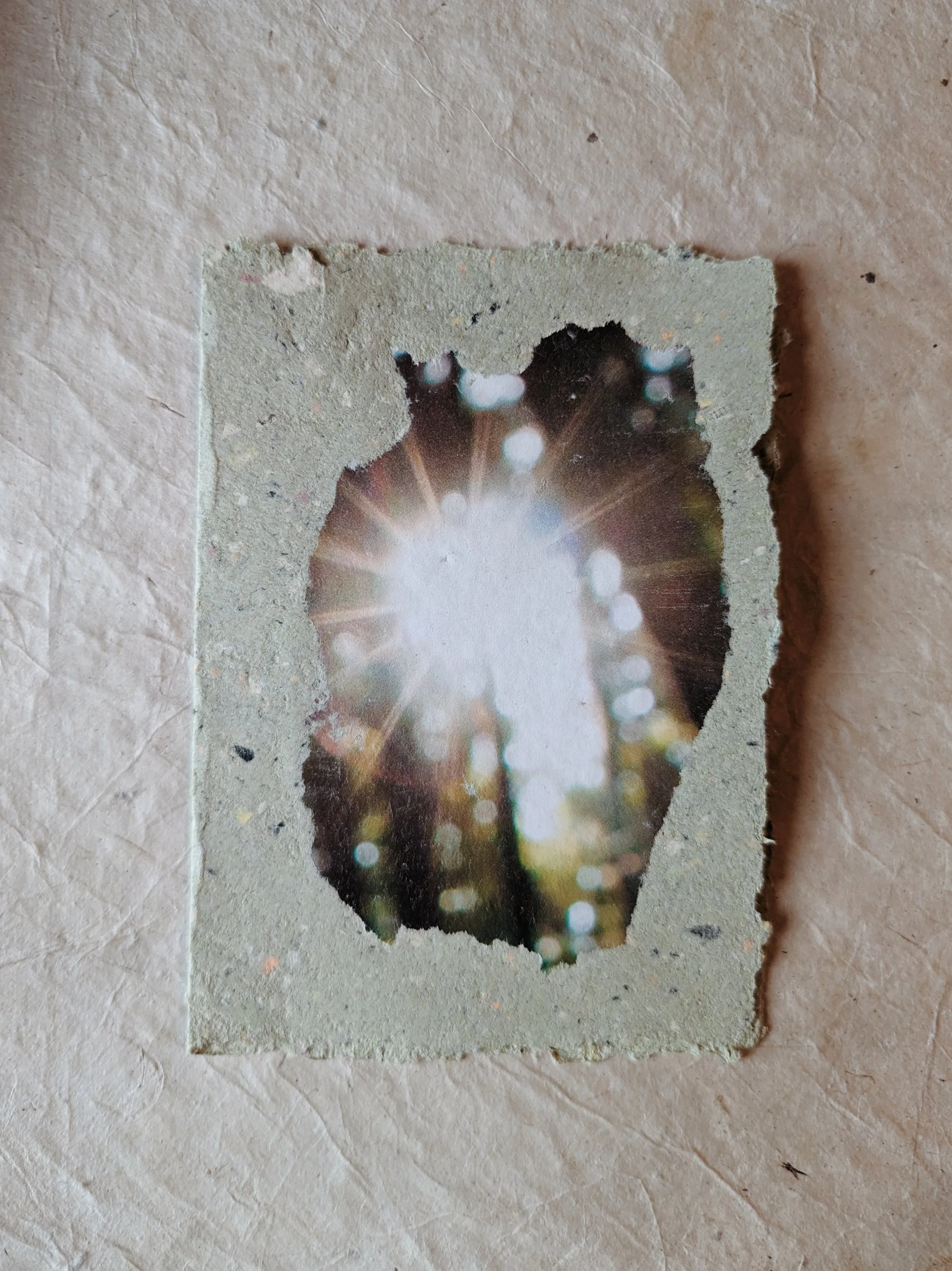Fotografie eines ausgeschnittenen Bilds mit Sonnenlicht und Bokeh-Effekt, auf einem Steintisch.