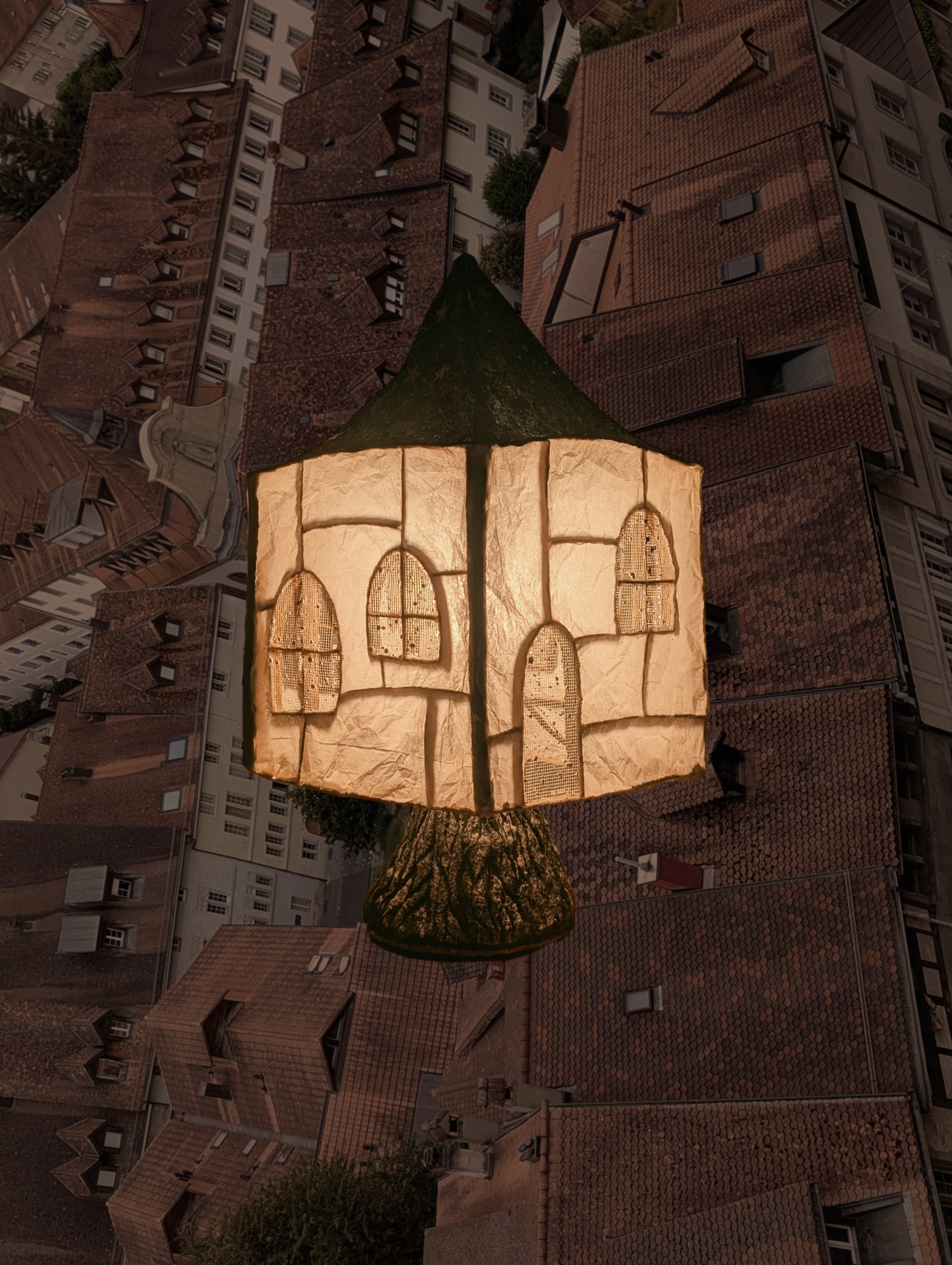 Ein beleuchtetes Papierlampengebäude, das auf einem Baum in einer städtischen Umgebung in der Nacht sitzt.