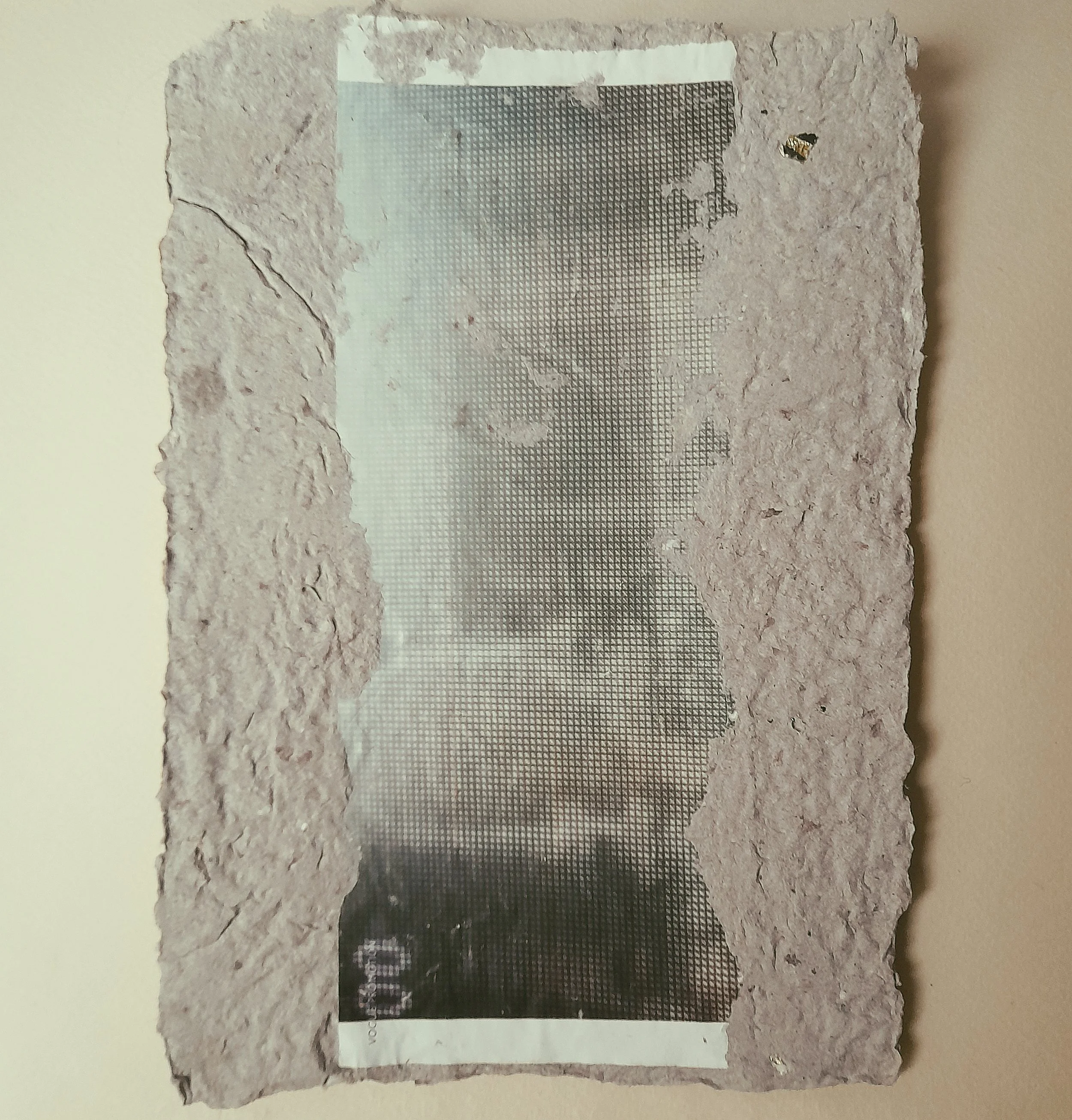 Verwitterte, geraffte Zigarettenpackung mit einem Porträt auf der Vorderseite, teilweise abgerissen, auf einer beige Wand