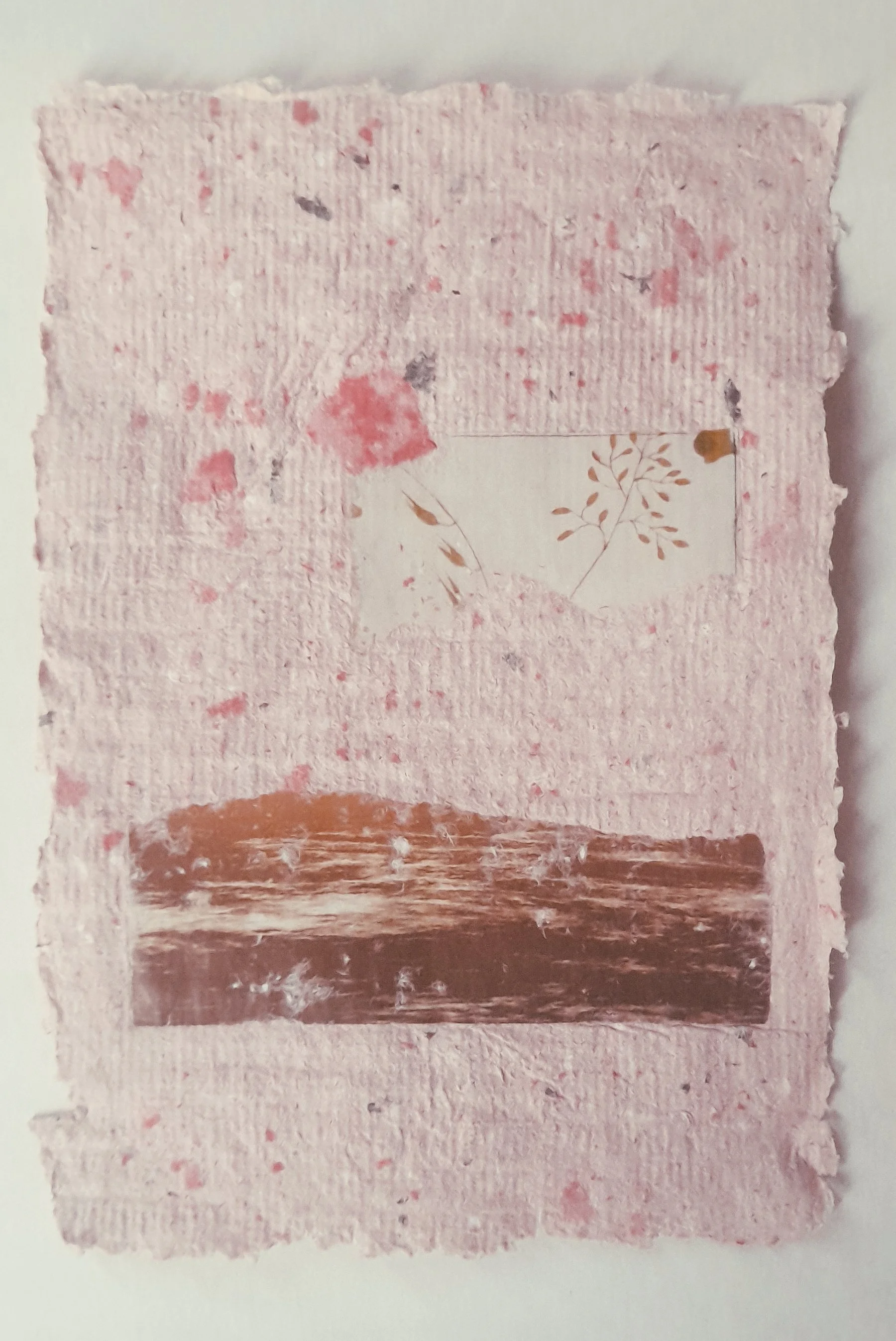 Eine Collage aus mehreren Schichten von handgeschöpftem, pinkfarbenem Papier mit kleinen Farbflecken und unterschiedlichen Texturen, auf dem sich ein kleines Stück mit einem Pflanzenmuster befindet.