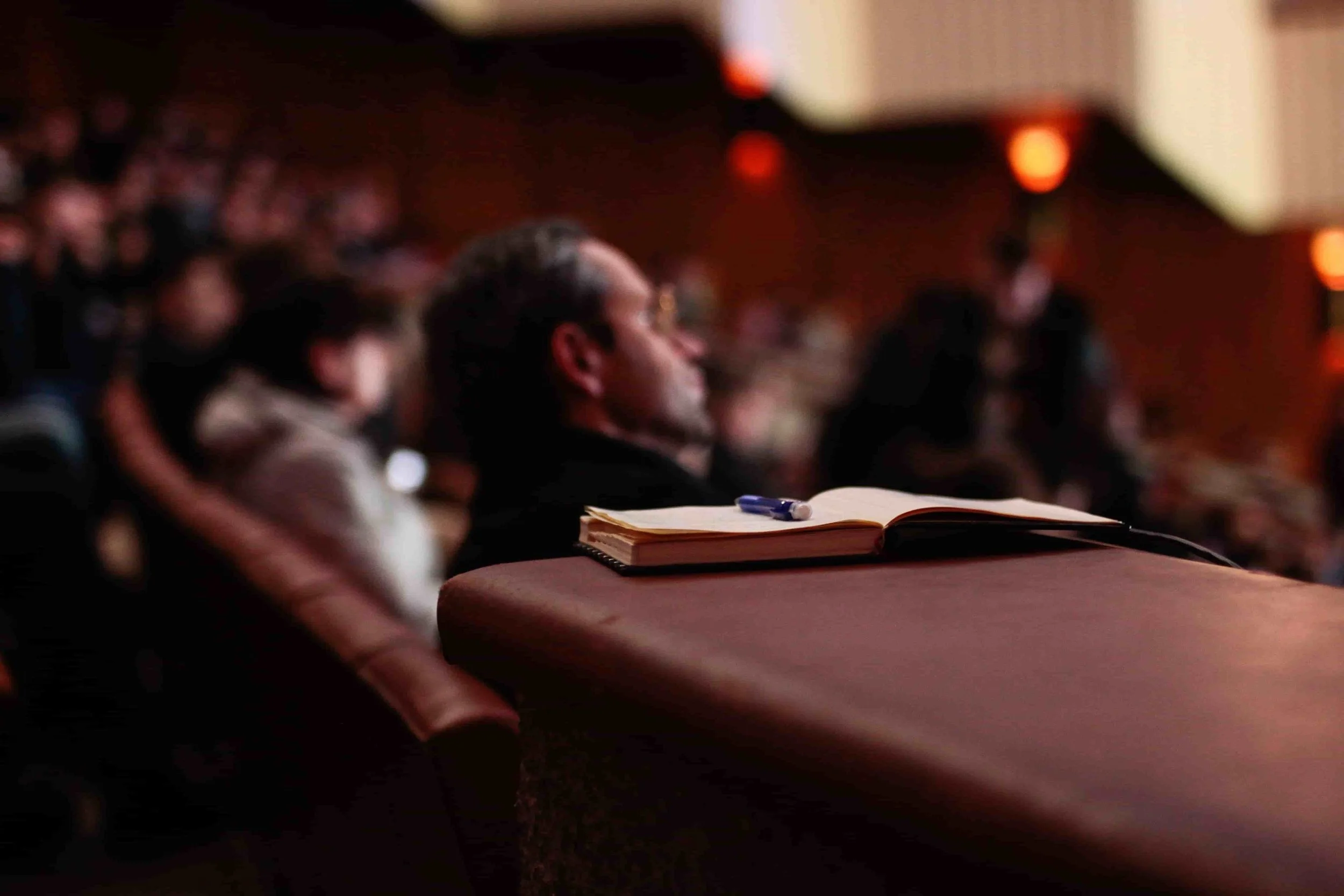 Man sitting in a room listening to a conference