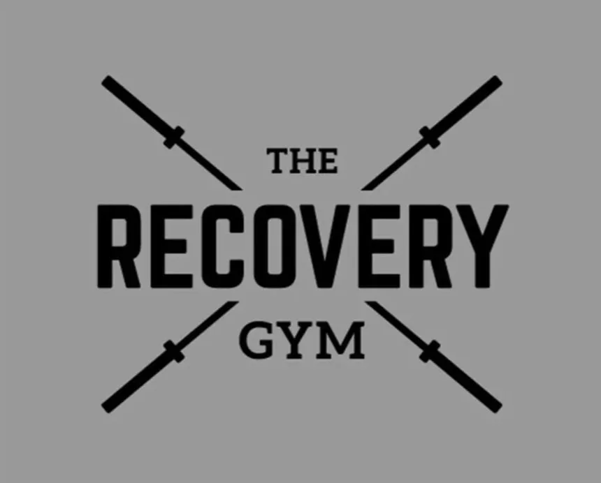 Logo for 'The Recovery Gym' with four barbells crossing behind the text.