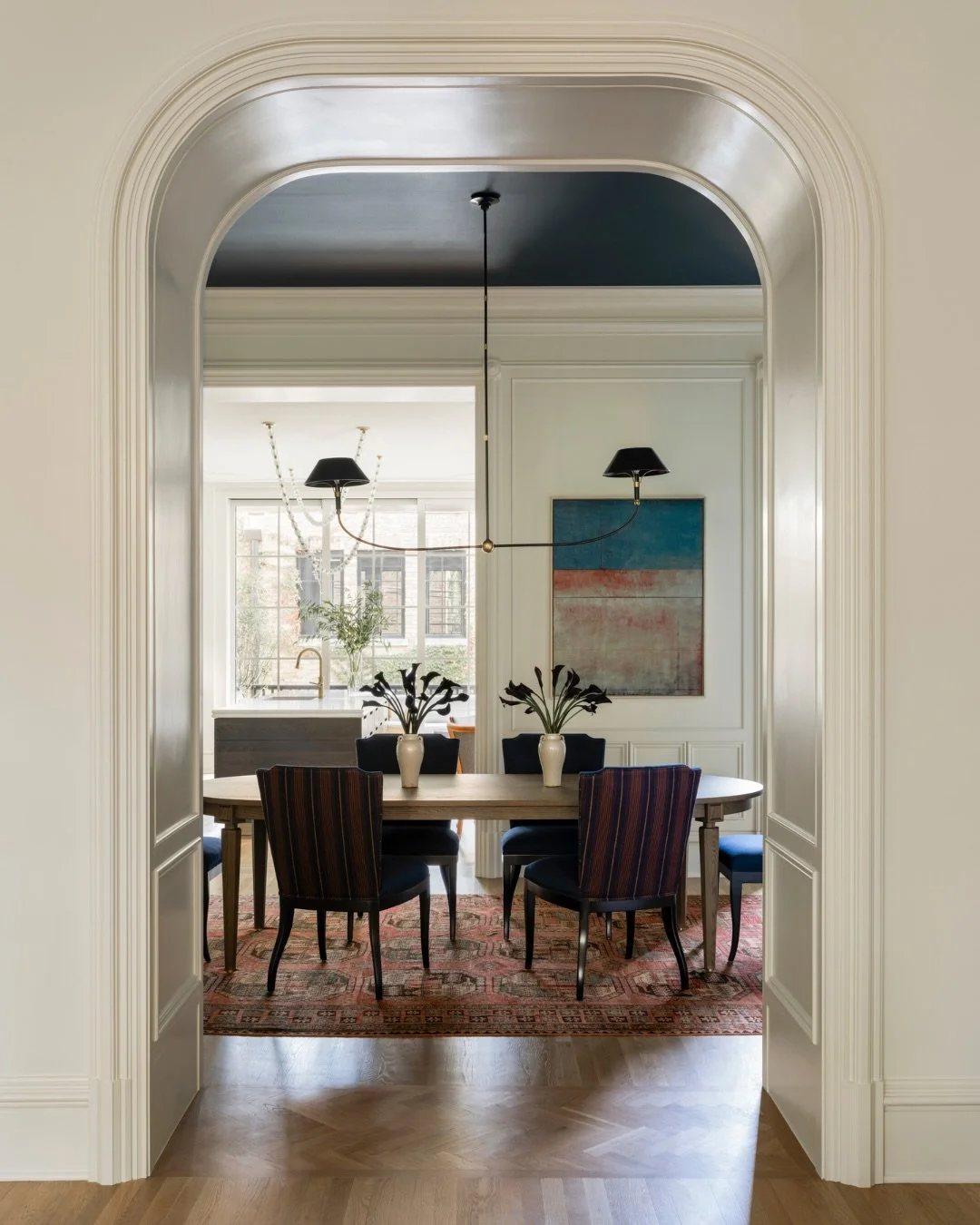 This cased opening is a case study in intentional room divisions.

Details that played up the intrigue of this architectural detail:
- Panel molding
- Flexible casing
- Herringbone turn board
- Electrical outlets for easy access from neighboring room