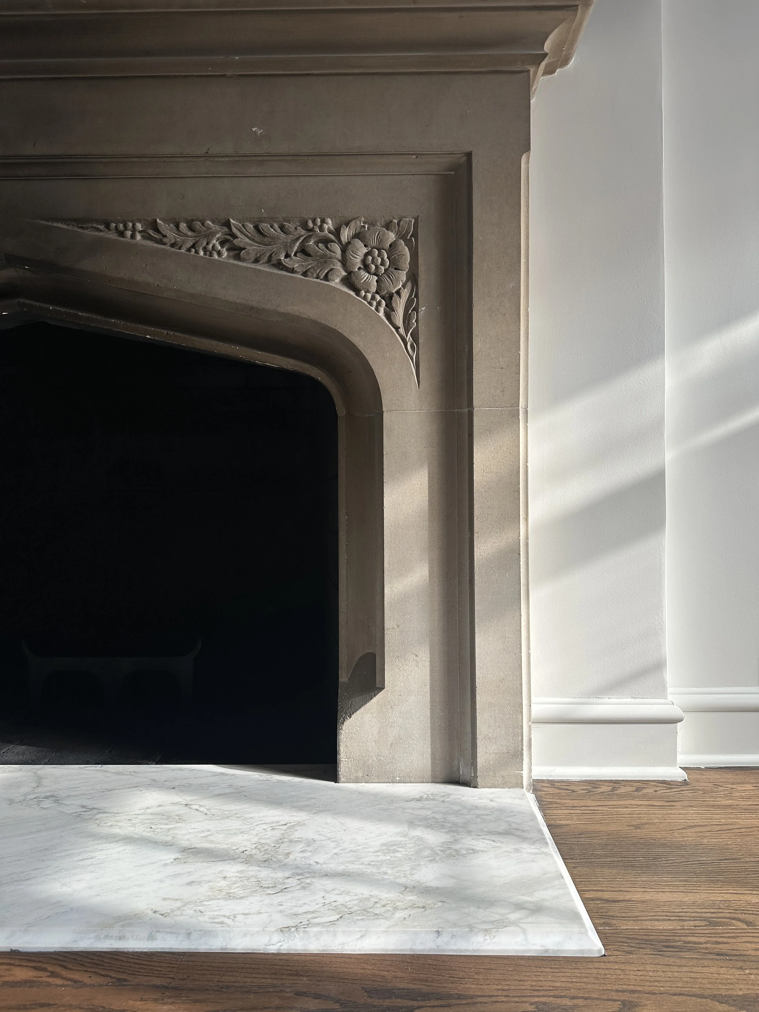 An original stone fireplace surround preserved and refinished by Ratia Construction
