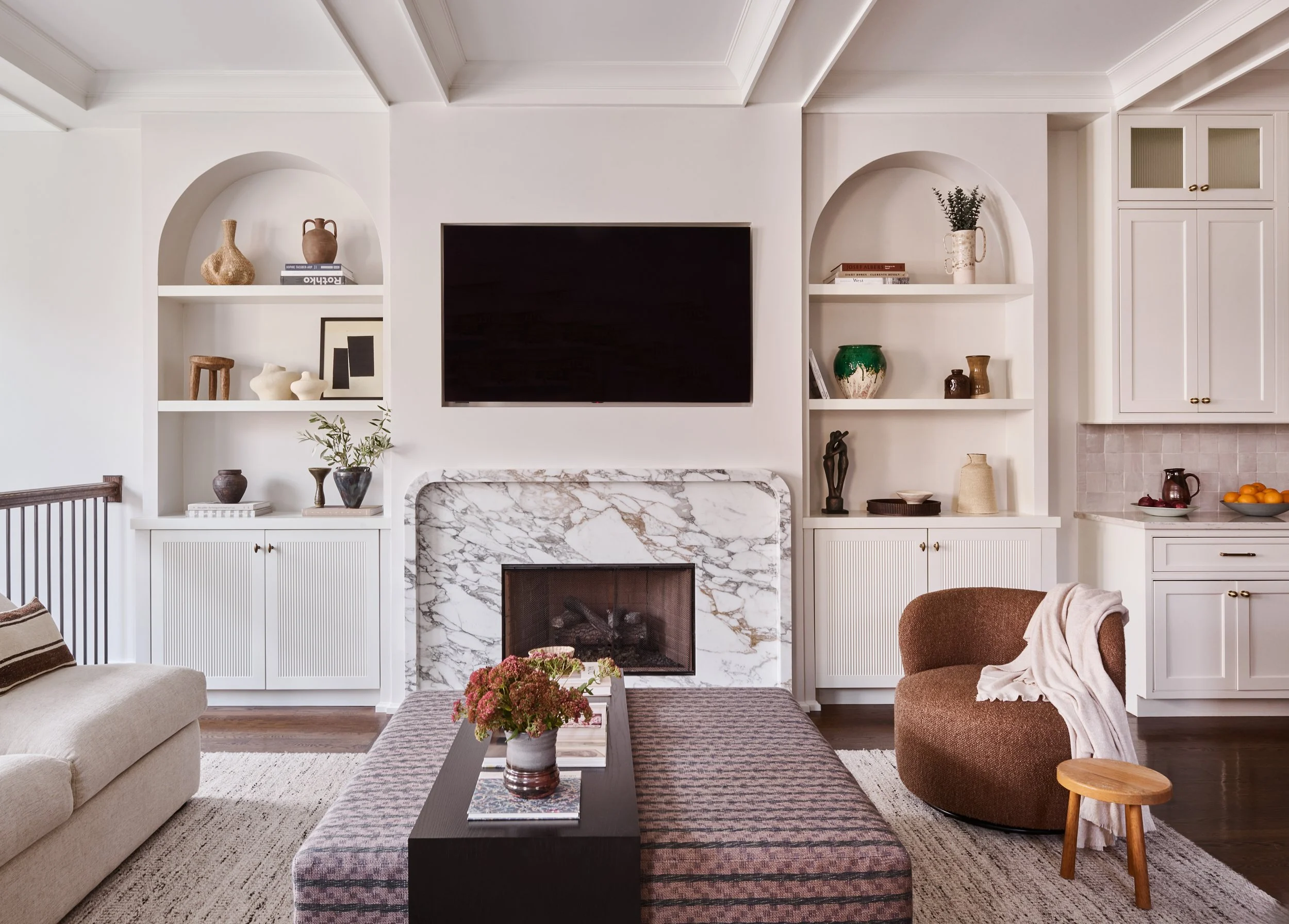 A symmetrical living room with arched built-in bookcases