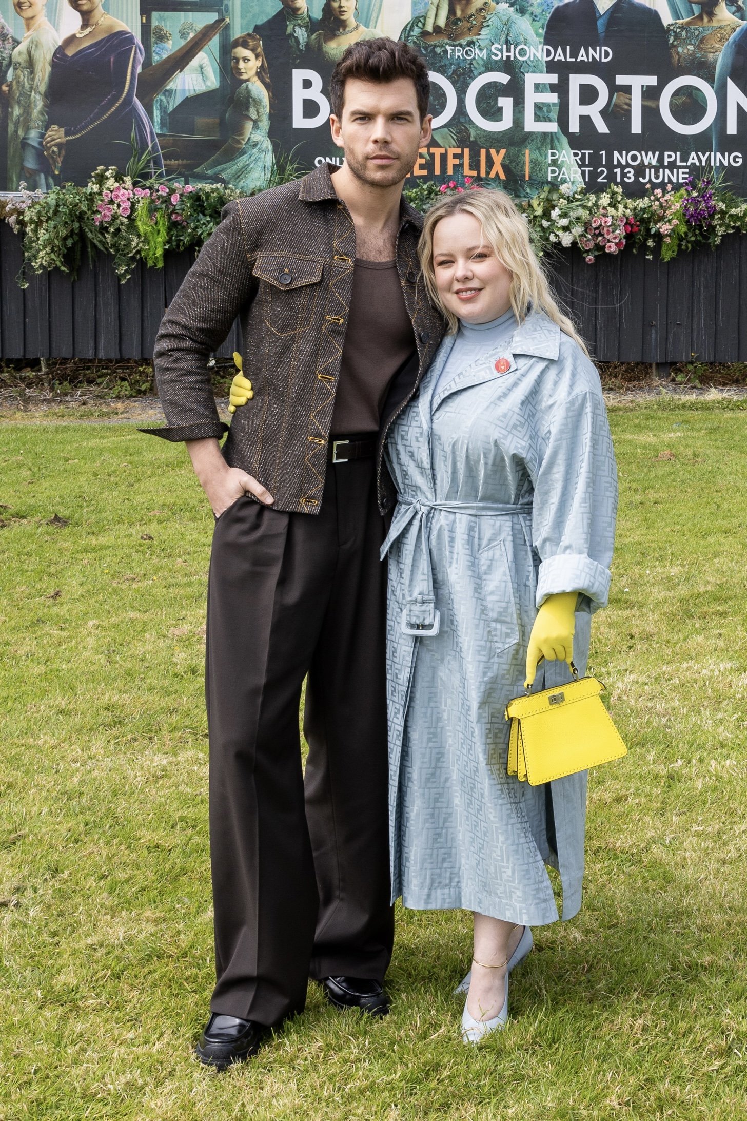 Nicola Coughlan and Luke Newton in front of 3d floral billboard display for Bridgerton Season 3 in Galway