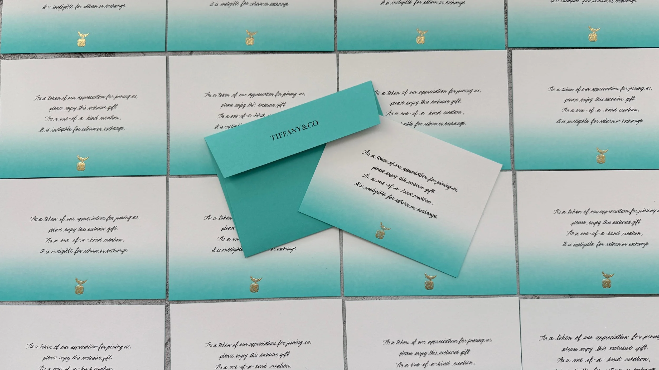 Collection of Tiffany & Co. gift cards with the Tiffany & Co. logo and a gradient blue-to-white background, arranged on a gray tiled surface.