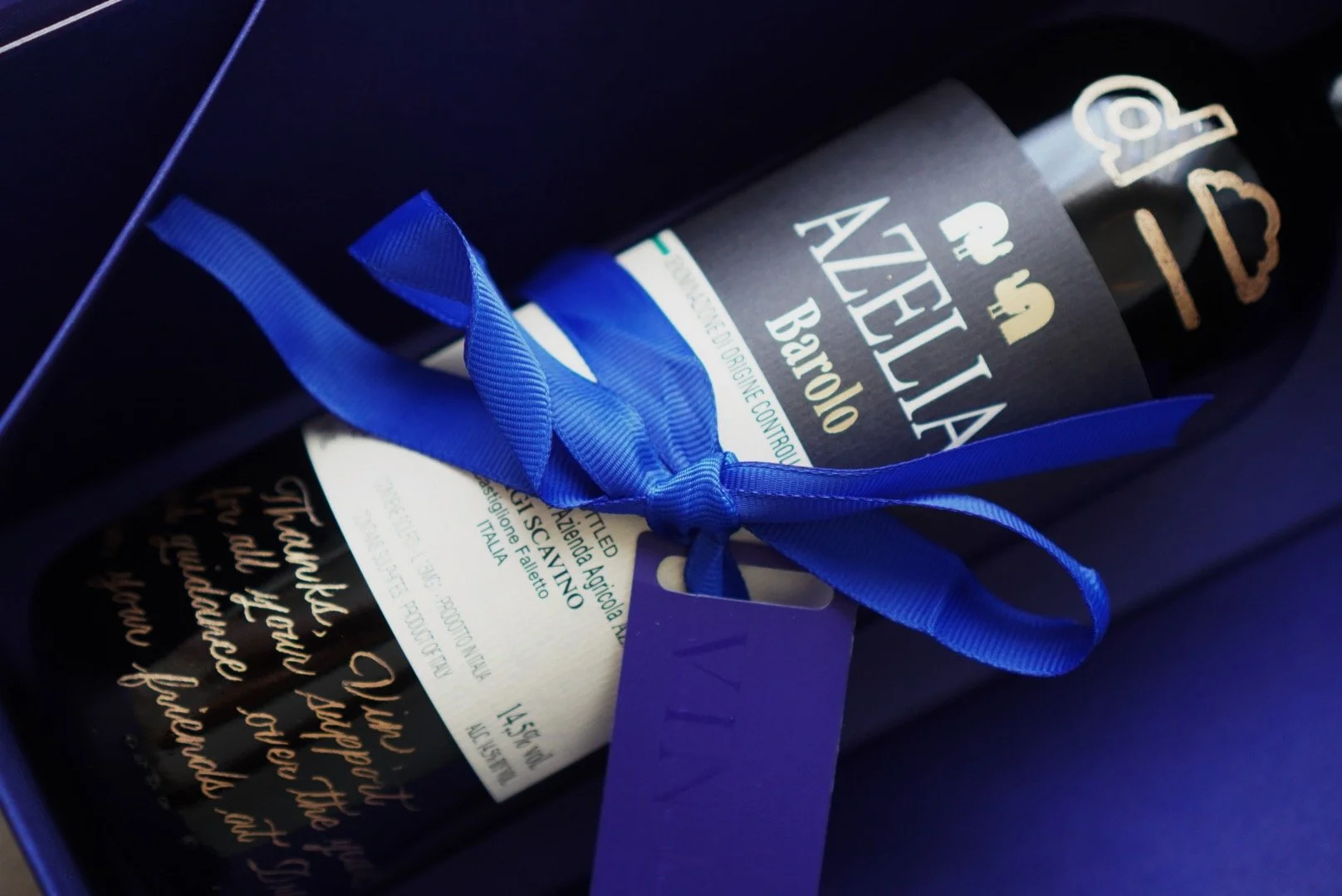 A gift box with a bottle of Azelia Barolo red wine tied with a blue ribbon.