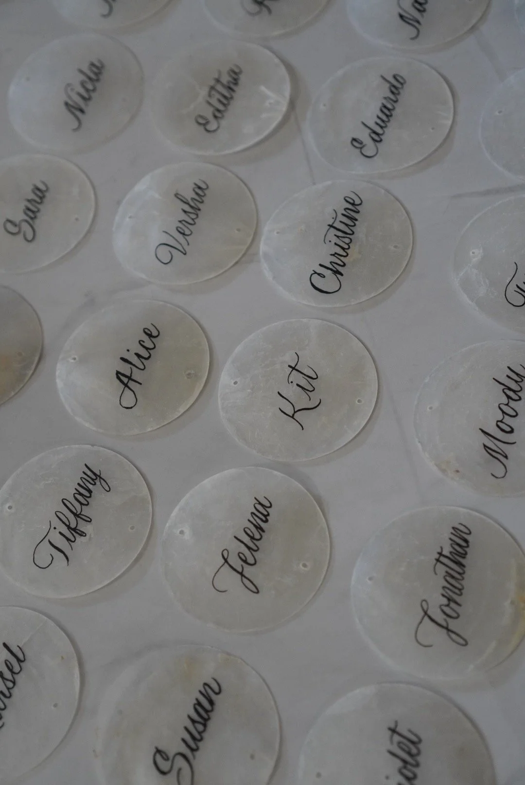 Clear circular stickers with handwritten black text of various names and words including 'Nick,' 'Edward,' 'Vero,' 'Kitt,' 'Tiffany,' 'Jelena,' 'Sofia,' and 'Marina.'