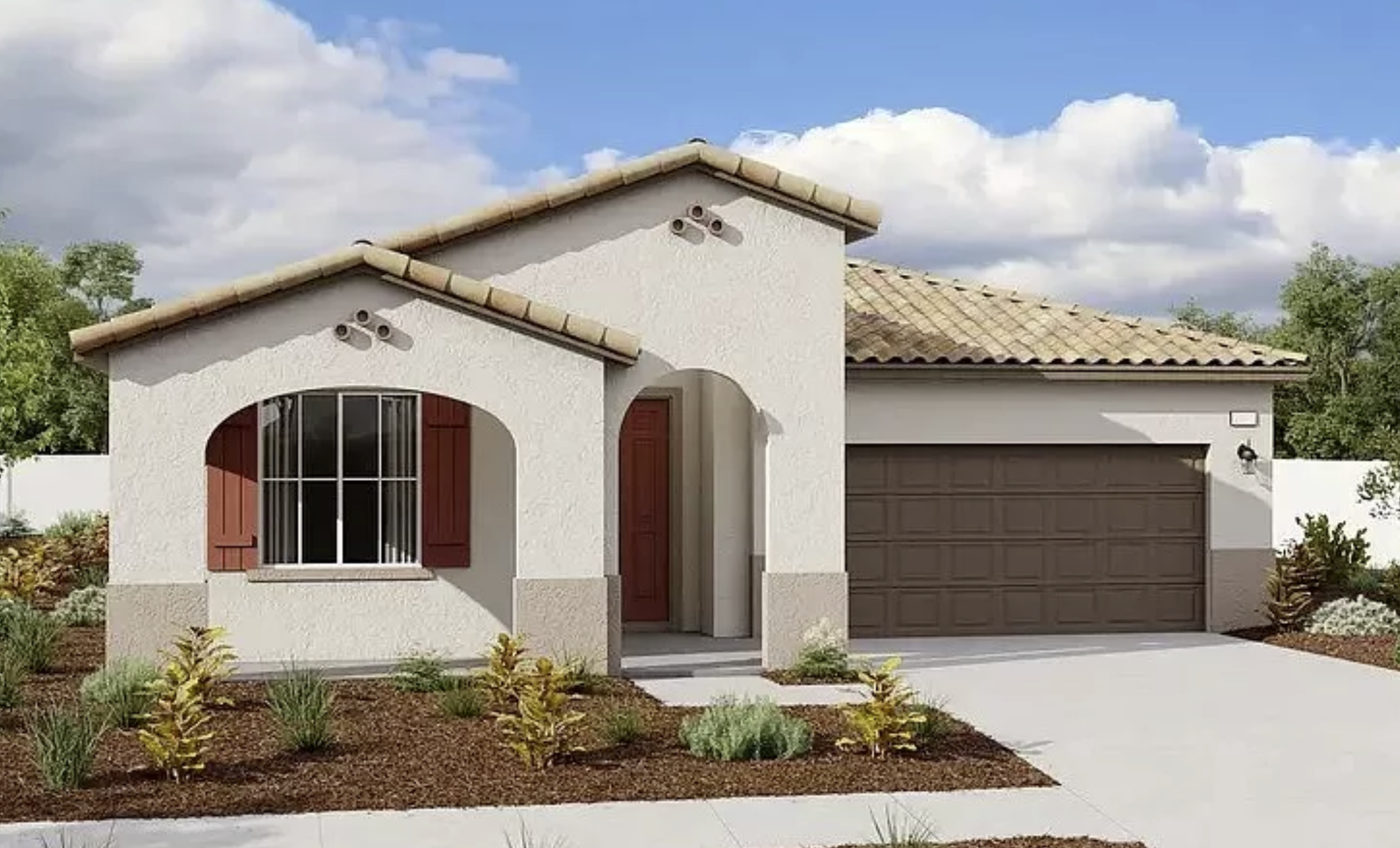 A modern single-story house with white stucco walls, a brown garage door, and a small front garden with desert plants, against a partly cloudy sky.