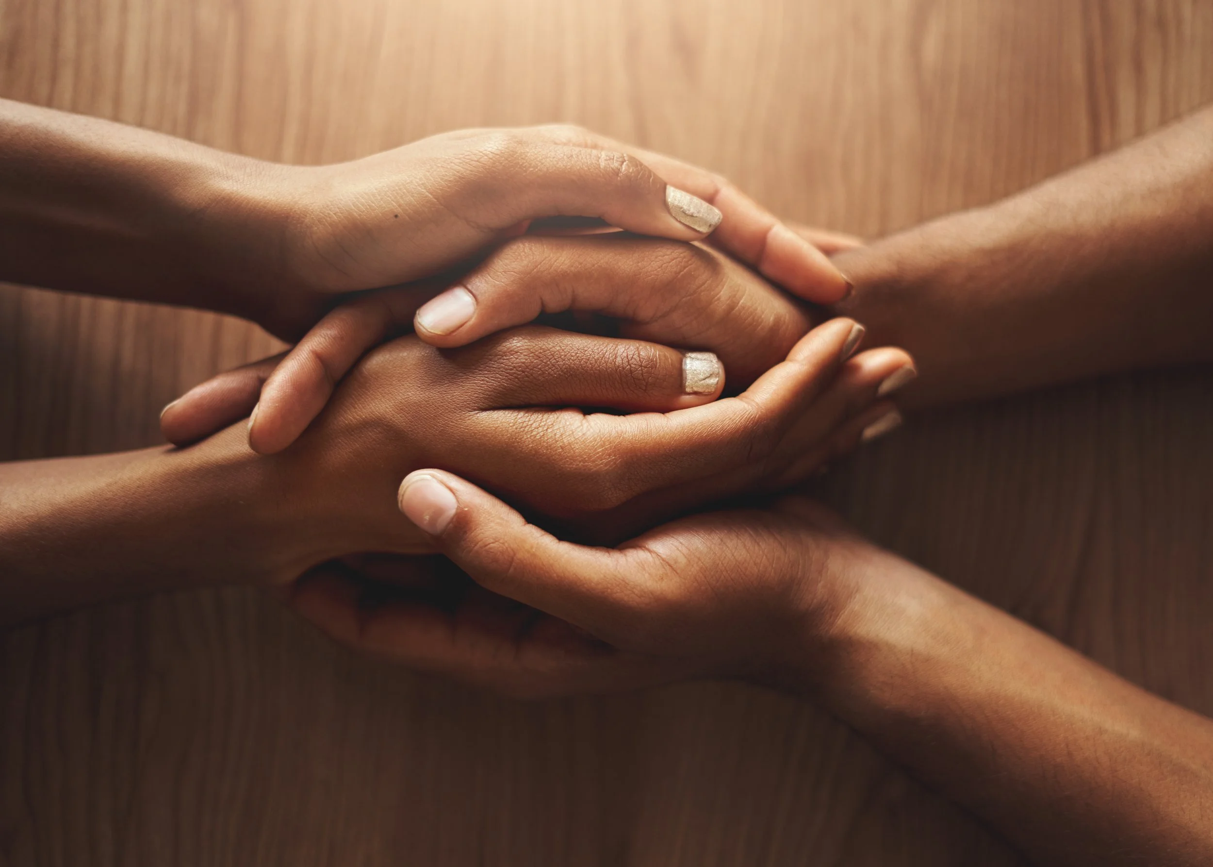 Hands resting together, representing family and relationship support