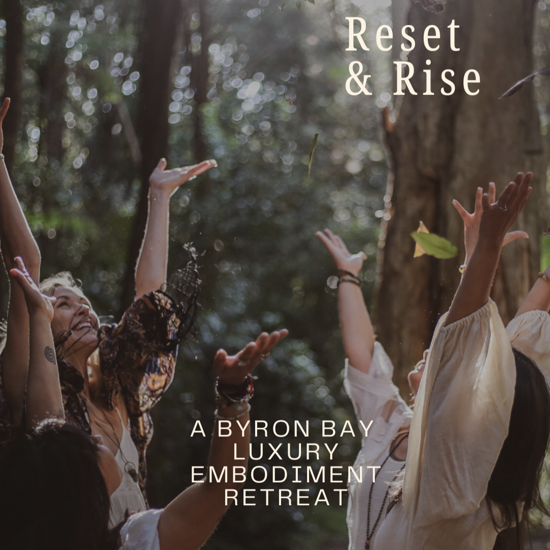 Group of women outdoors in a forest, arms raised, celebrating at a retreat titled 'Reset & Rise' with text indicating 'A Byron Bay luxury embodiment retreat'.