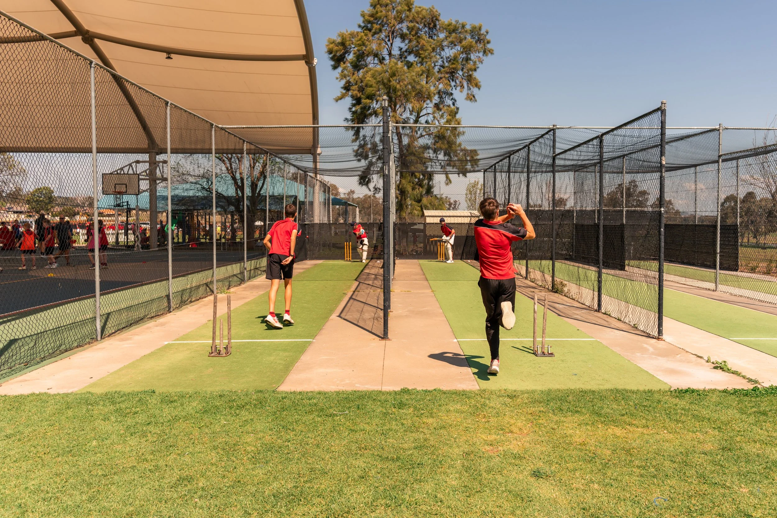 Students playing cricket in the cricket nets at Carinya Christian School, Tamworth.