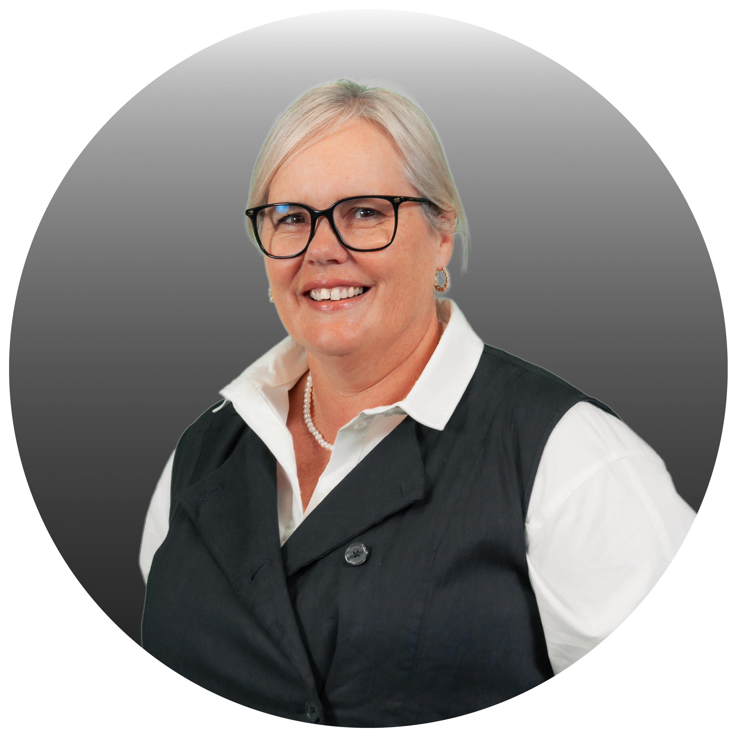 Portrait of a middle-aged woman with gray hair, glasses, wearing a white shirt and a black vest.