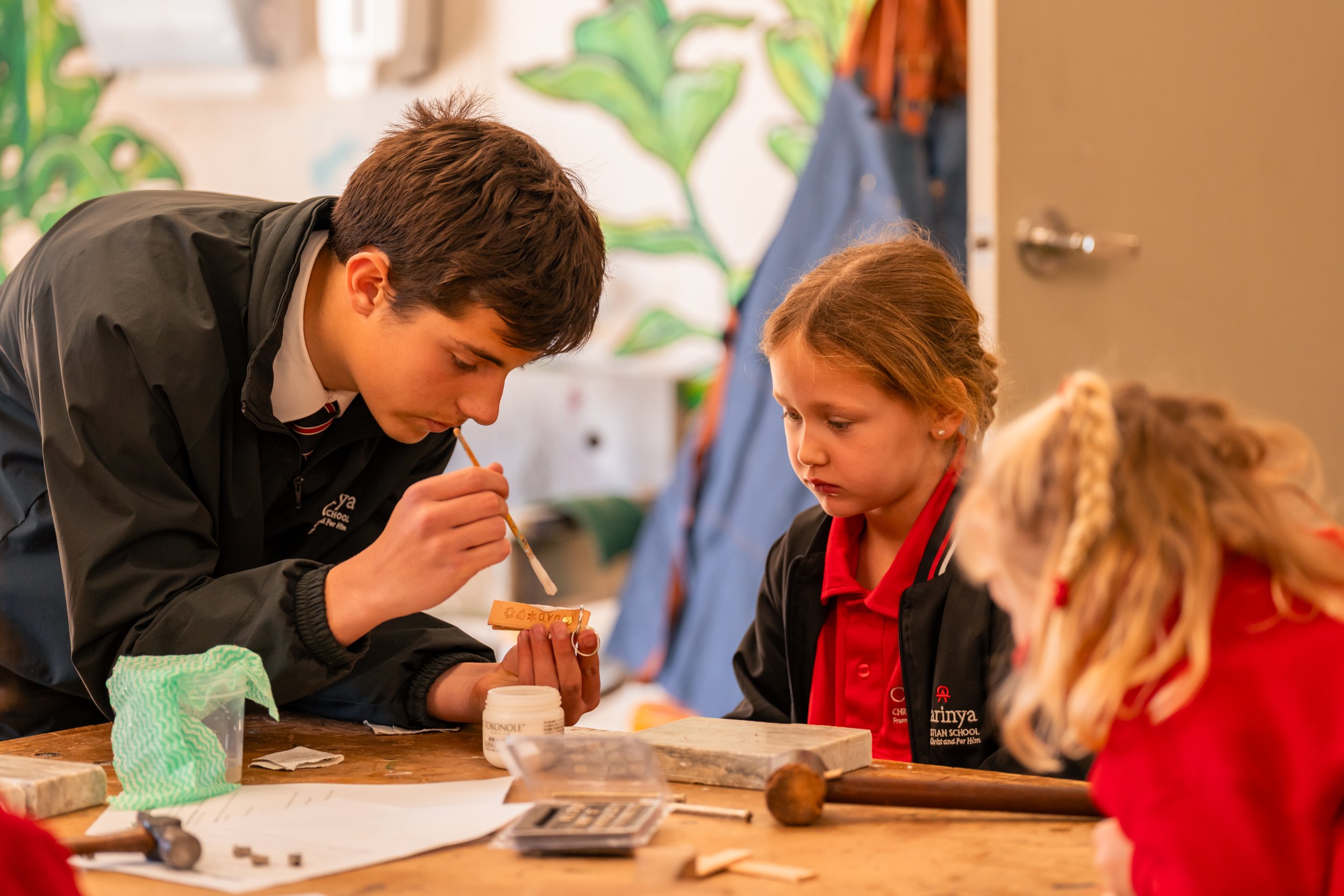 A senior School Student helping a Lilly Pilly Prep student in a classroom at Carinya Christian School, Tamworth