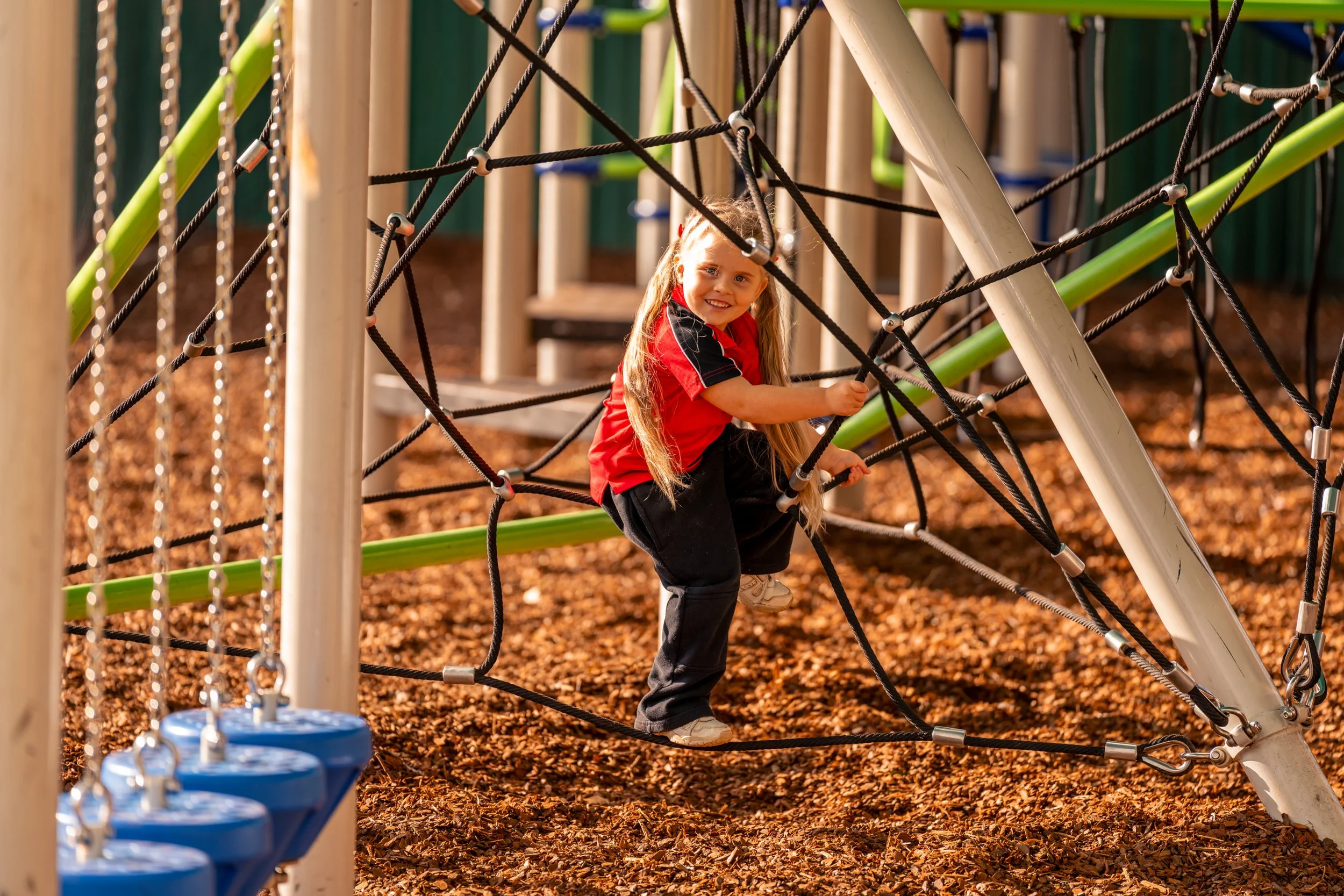 A Prep Student on the Junior School outdoor play equipment and climbing gym at Carinya Christian School, Gunnedah.