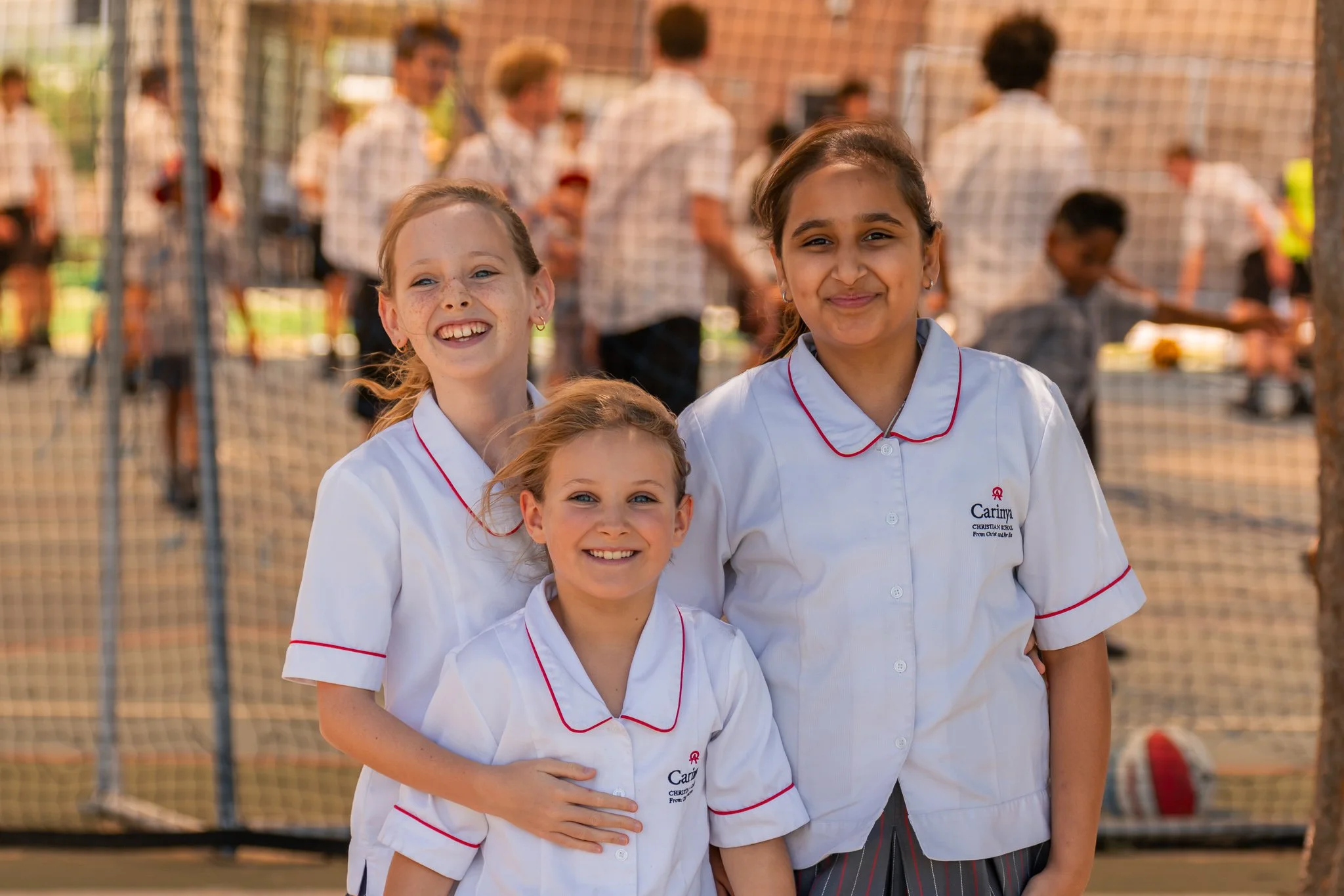 Junior school girls standing outside in the undercover basketball courts at Carinya Christian School, Tamworth.