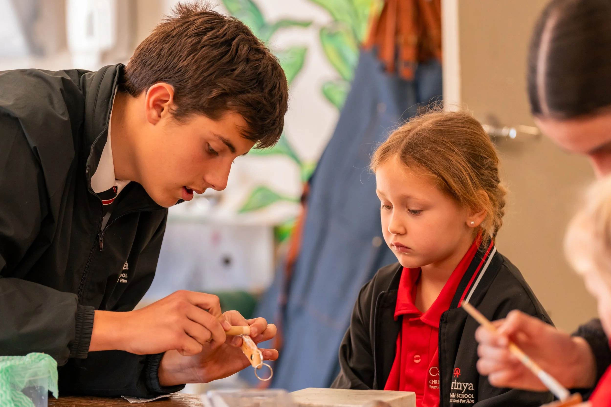 A Carinya Senior student helping a Prep student during a design and technology class inside a classroom at Carinya Christian School, Tamworth