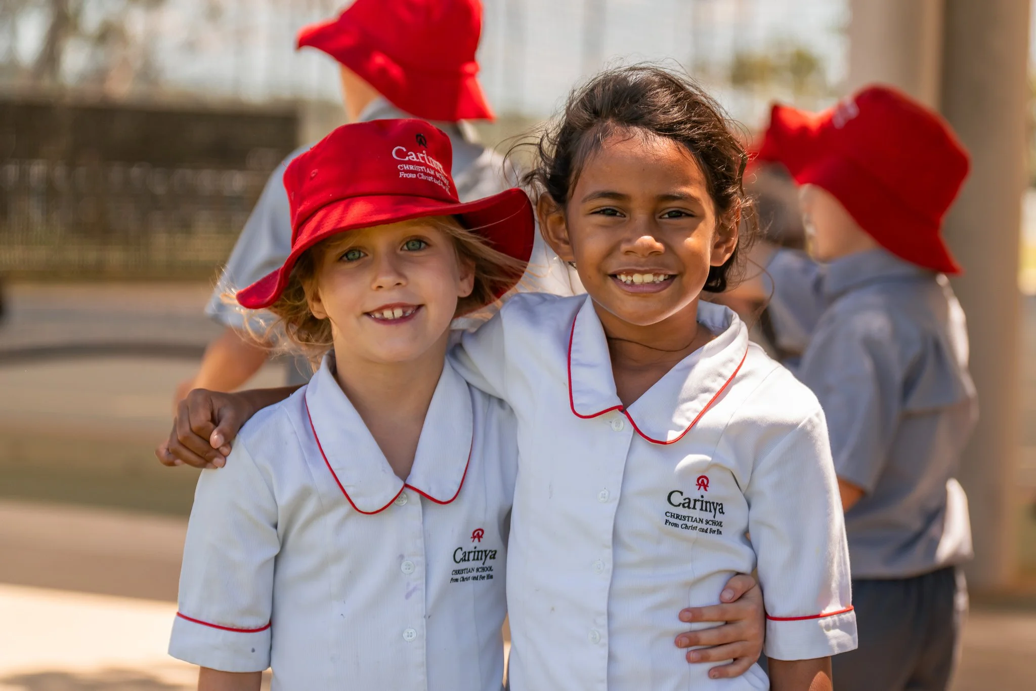 Junior school girls standing outside in the undercover basketball courts at Carinya Christian School, Tamworth.