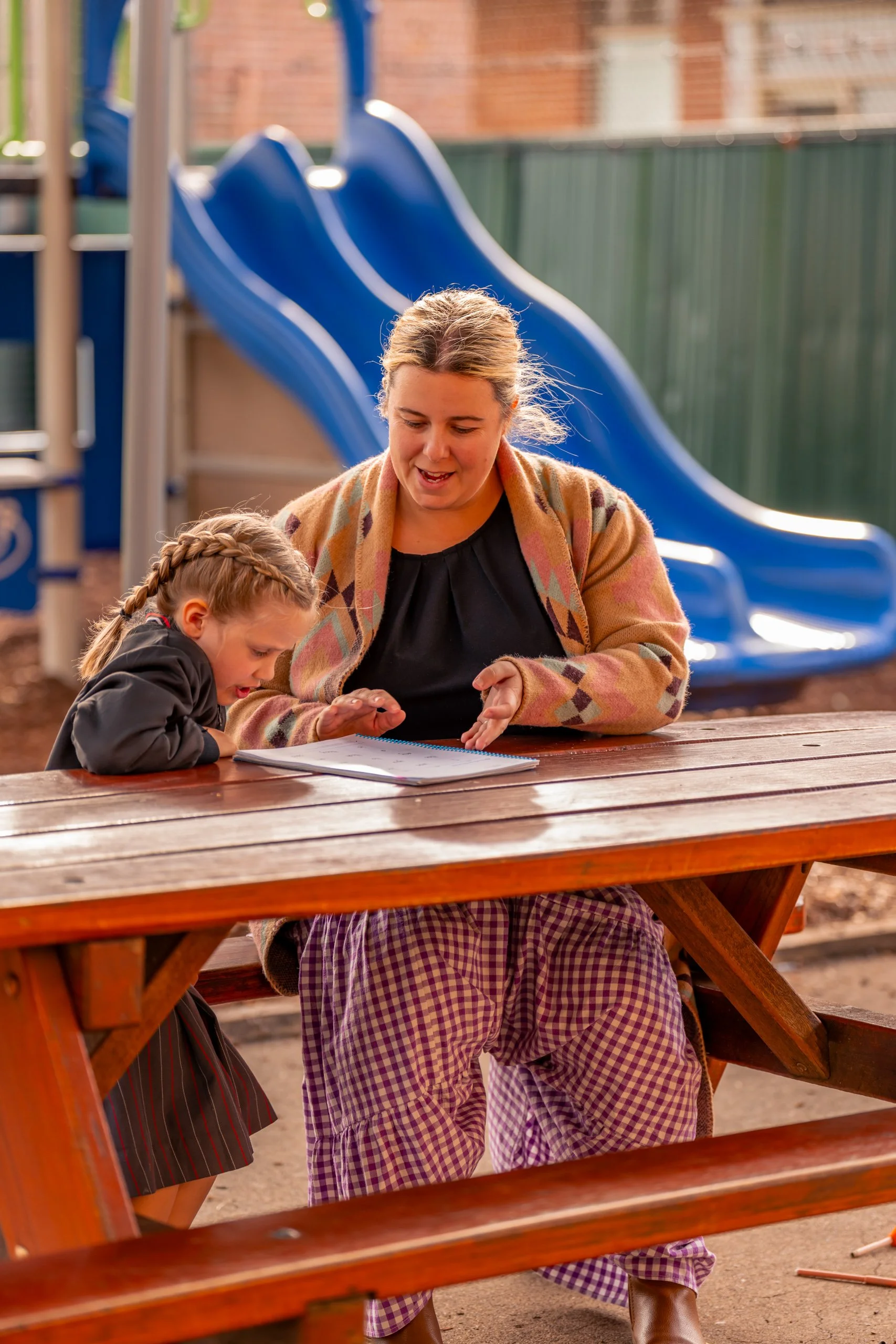 A Teacher and Student working together in the junior school outdoor area at Carinya Christian School, Gunnedah.