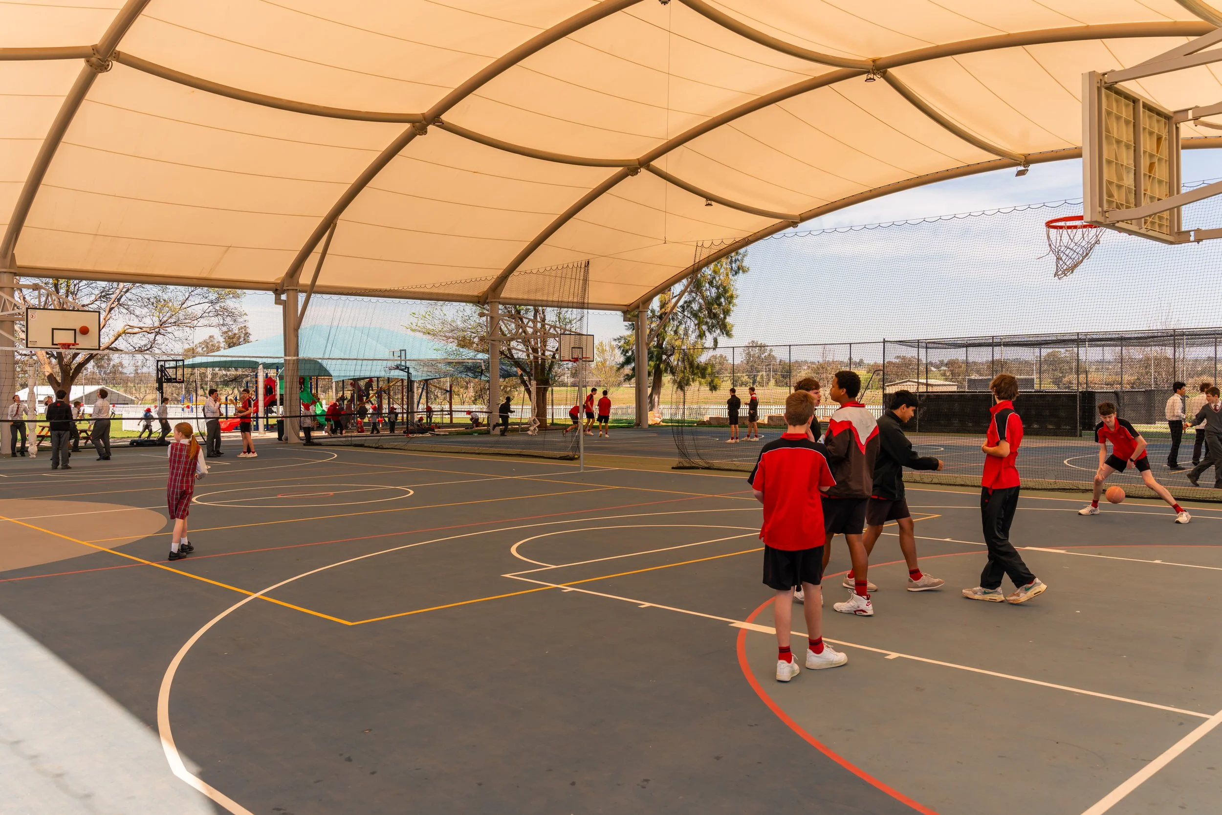 Carinya Students playing basketball and other sports on the undercover basketball court at Carinya Christian School, Tamworth.