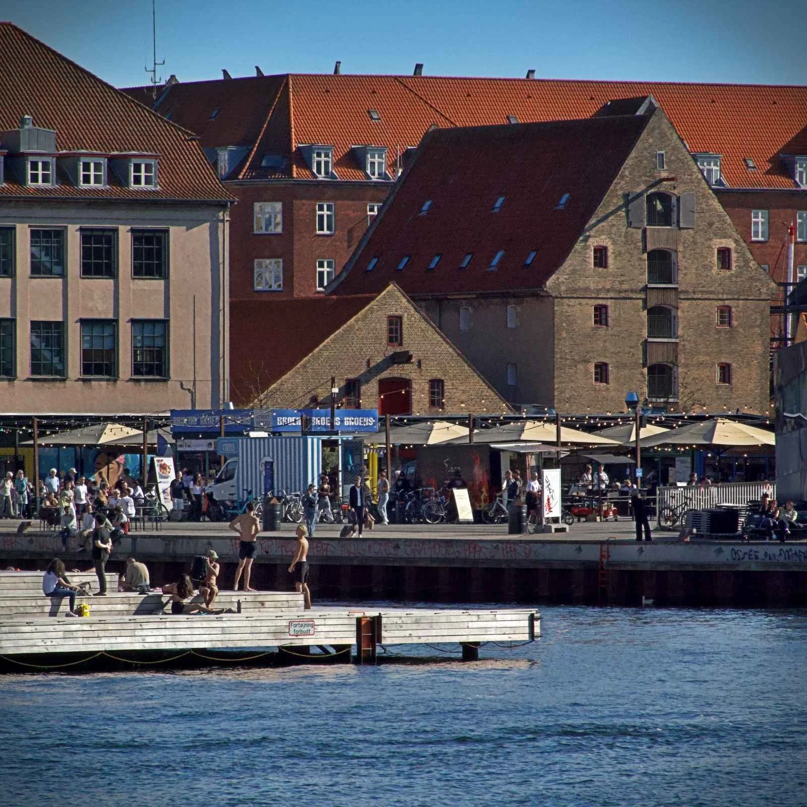 Außenaufnahme des Street-Food-Marktes Broens Gadekøkken in Kopenhagen am Paper Island, mit einer Menschenmenge, Essensständen und Sitzbereichen.