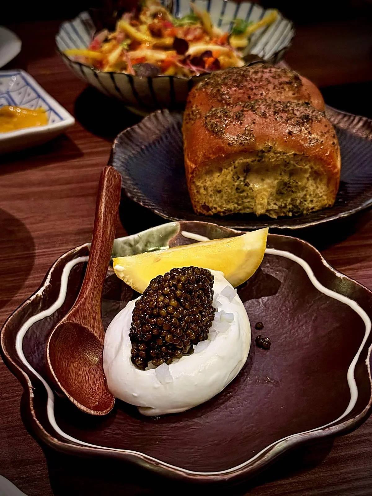 Rossini caviar on a white cream with a lemon wedge and Hokkaido brioche served on a plate at Miyakodori restaurant in Stockholm.