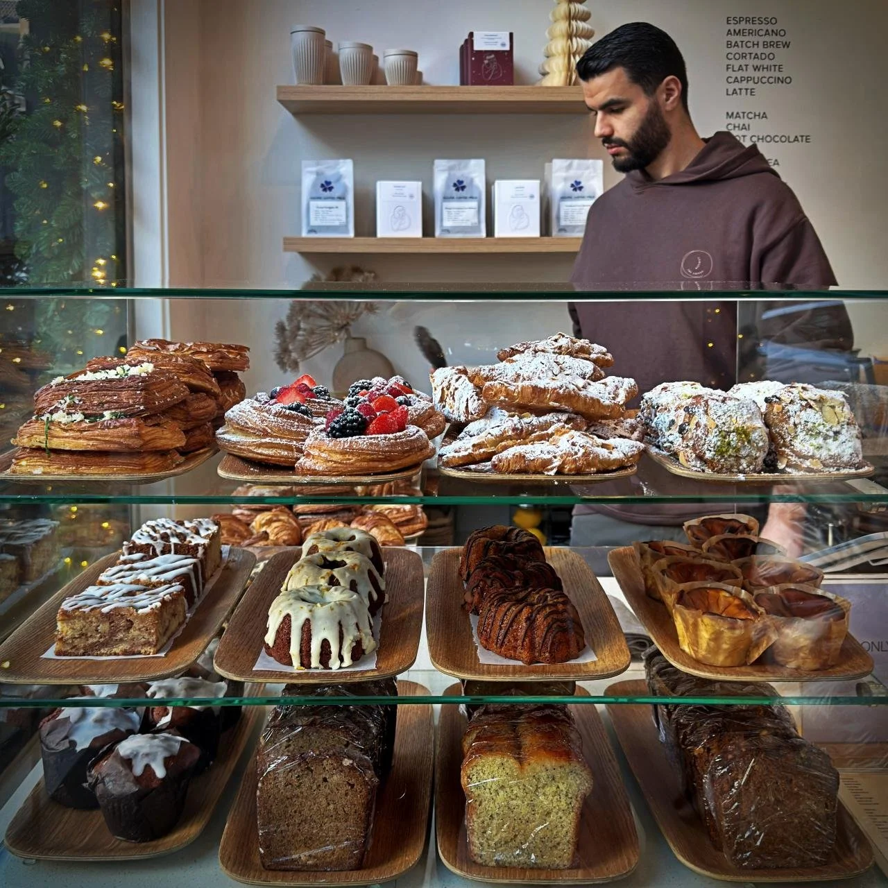 Pastry display at The Coffee District on Willemsparkweg in Amsterdam with a selection of croissants, cakes, cinnamon rolls and Danish pastries.
