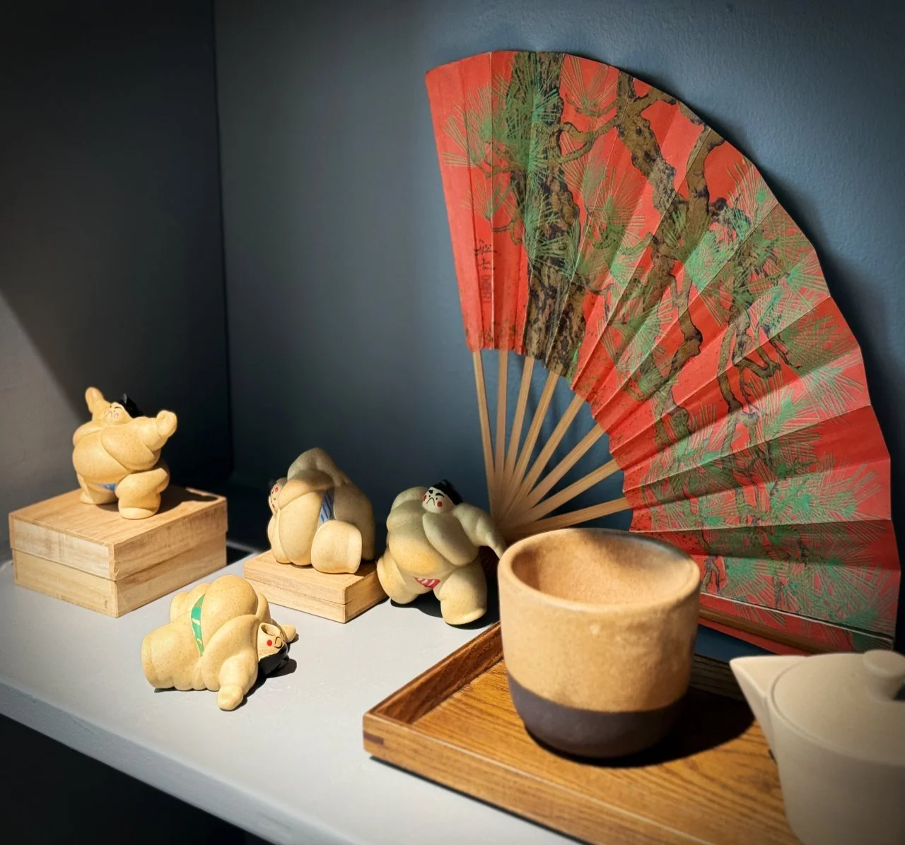 Shelves at Sakura Copenhagen in the Frederiksberg district display Japanese folding fans, tea cups, and small red Daruma dolls. The selection features traditional Japanese craftsmanship and minimalist interior design.