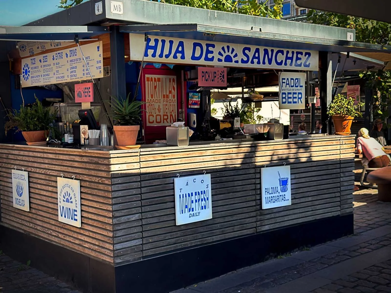 Taco-Stand Hija de Sanchez in den Torvehallerne Kopenhagen mit Holzfassade und Schildern für Tortillas und Bier.