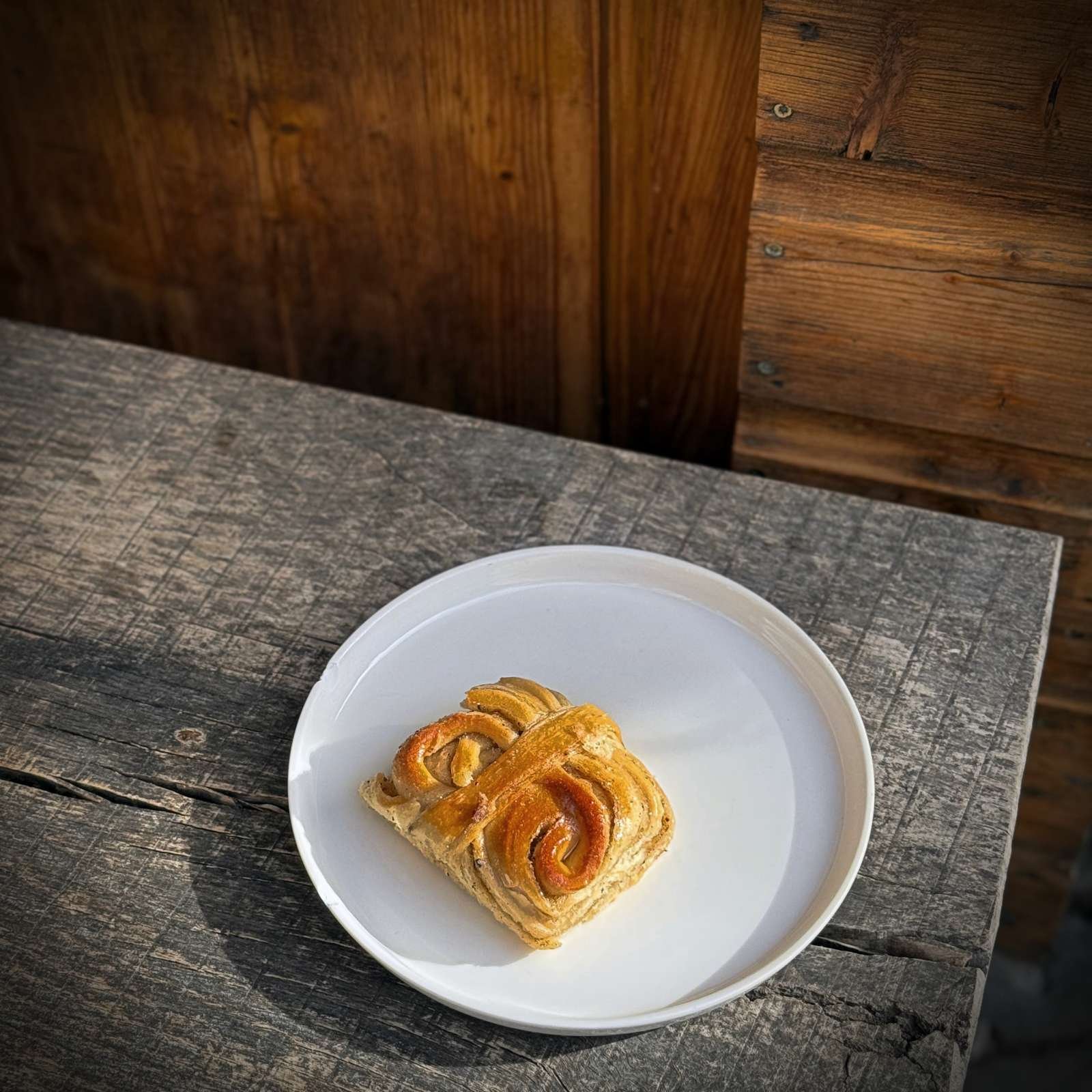 A cinnamon roll on a white plate at Café Suuapinga at Wiener Platz in Munich.