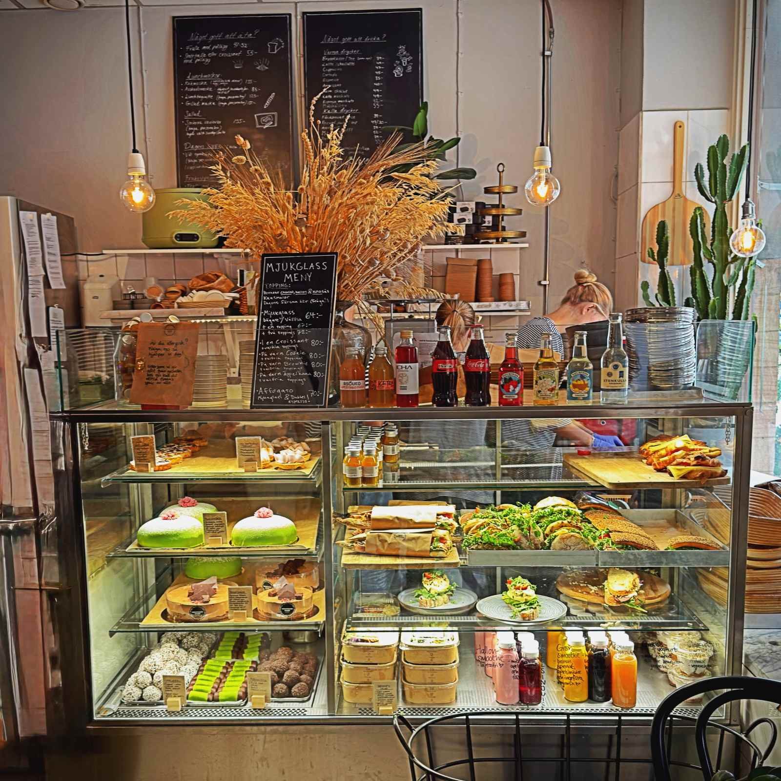 Blick auf die Verkaufstheke der Bäckerei Bergstrands Bageri in Stockholm mit Broten im Hintergrundregal sowie süßen Teilchen und herzhaften Gebäcken im Vordergrund.