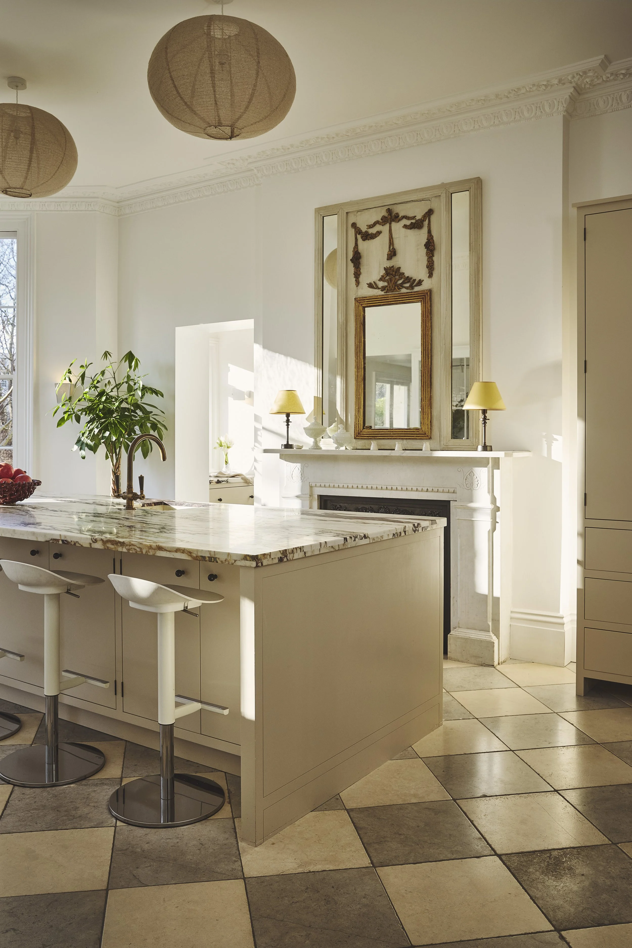 Checker board flagstone flooring in a cream shaker kitchen with marble worktop