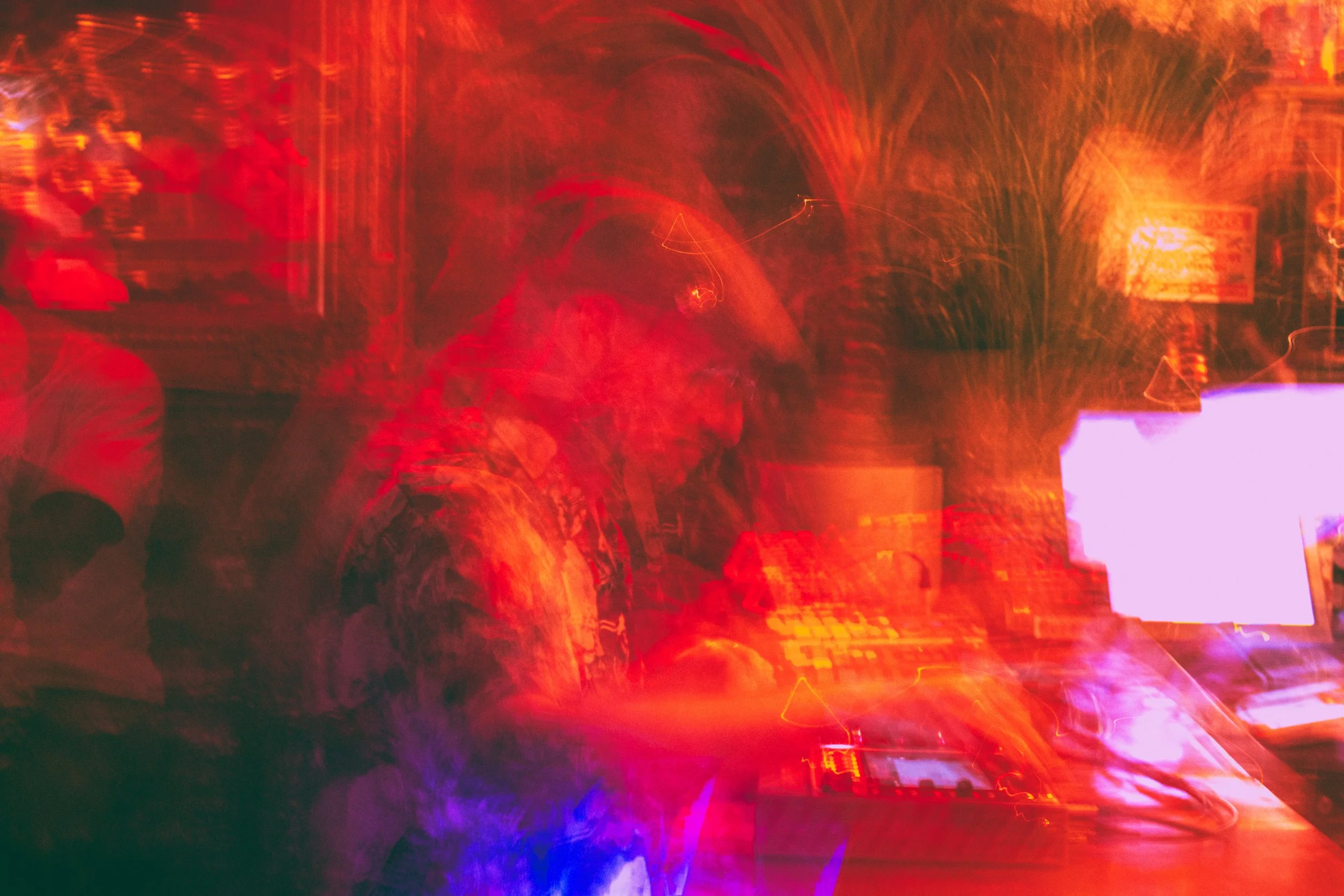 A highly abstract image with vivid red, orange, purple, and blue light streaks and patterns.