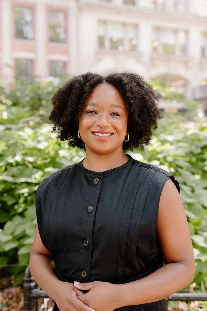 woman smiling stnading in front of bushes in Madison Square Park