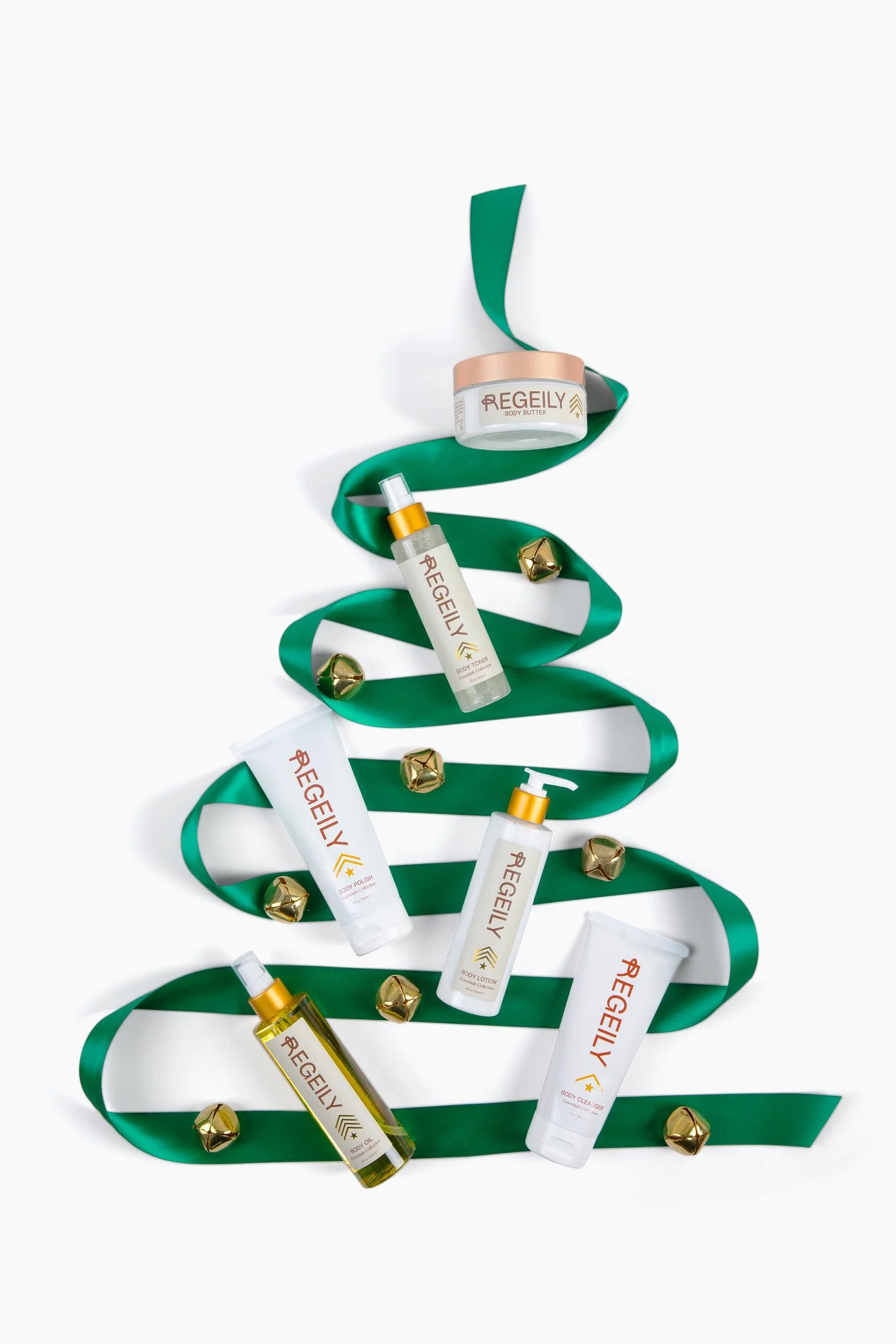 Regeily body-care products arranged along green ribbon in the shape of a Christmas tree.