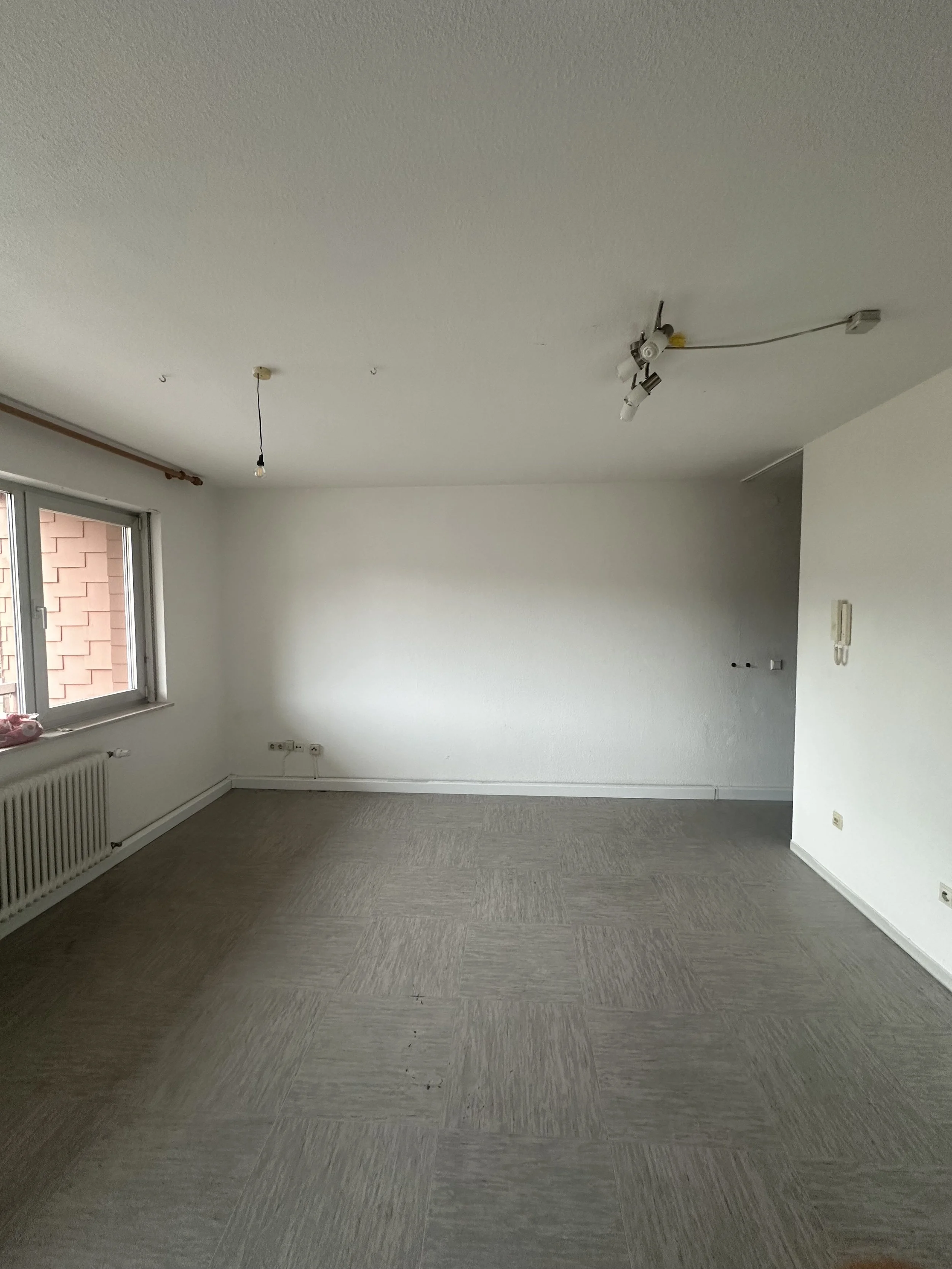 1. Ausgangssituation
Die Wohnung im Bestand: alte Tapeten, vergilbte Anstriche sowie Risse und Beschädigungen an den Wänden. Zu Beginn prüfen wir den Untergrund und beurteilen, welche Flächen tragfähig sind und welche Schichten entfernt werden müssen