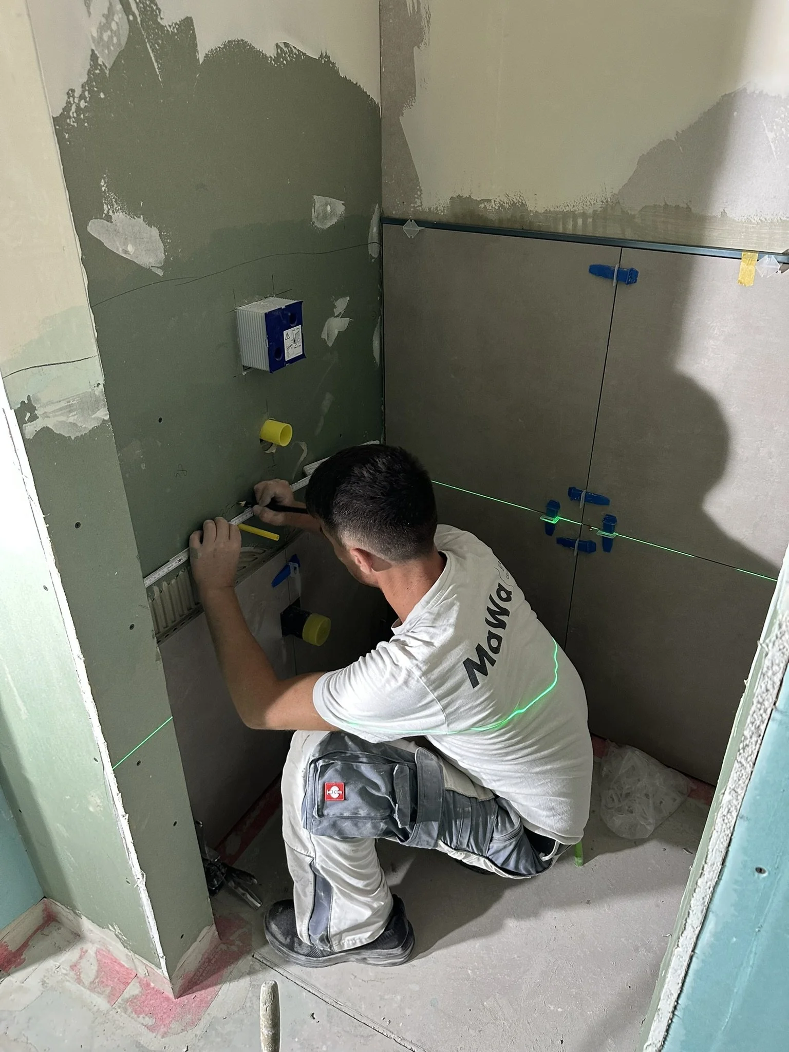 Ein Mitarbeiter der MaWa Bau GmbH arbeitet in einem Badezimmer