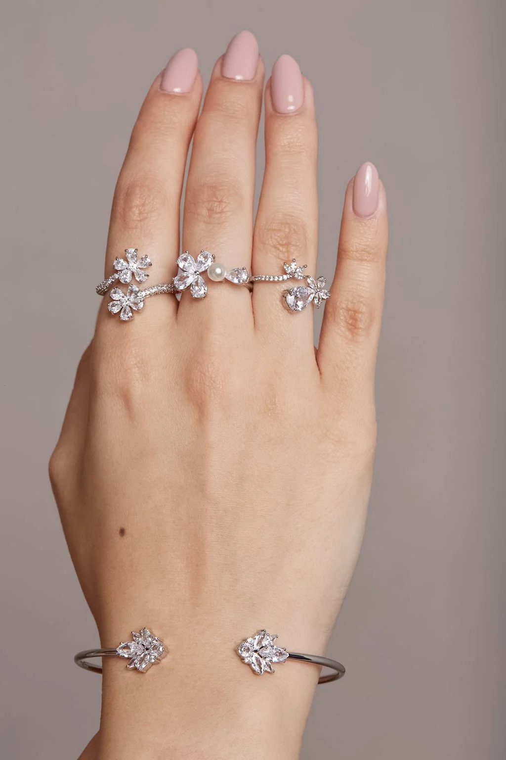 close up shot of hand showing silver rings with diamonds and matching bracelet by beauty photographer finegraphy