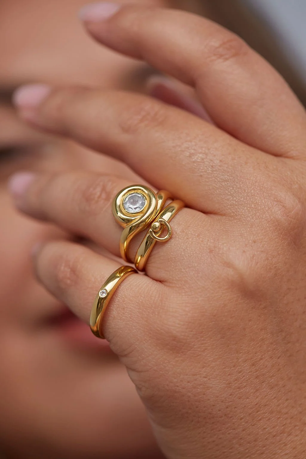 beautiful soft natural light beauty photograph of a models hands wearing size inclusive gold rings by zaleska jewelry