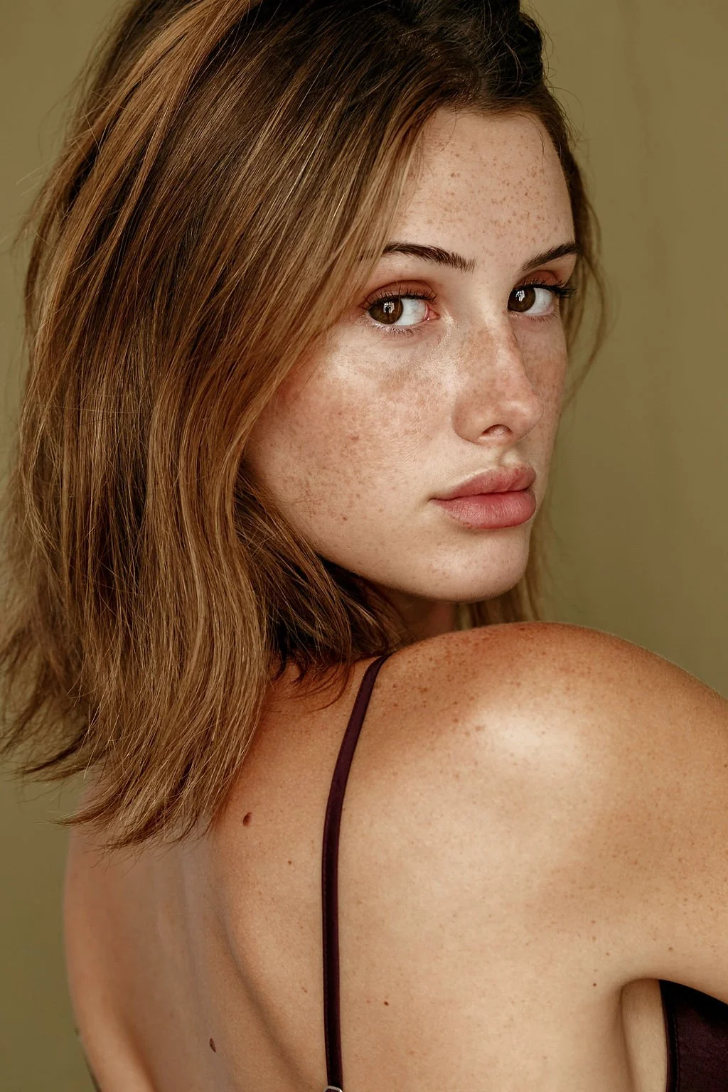 brunette beauty model looking over shoulder for studio portrait in Vancouver