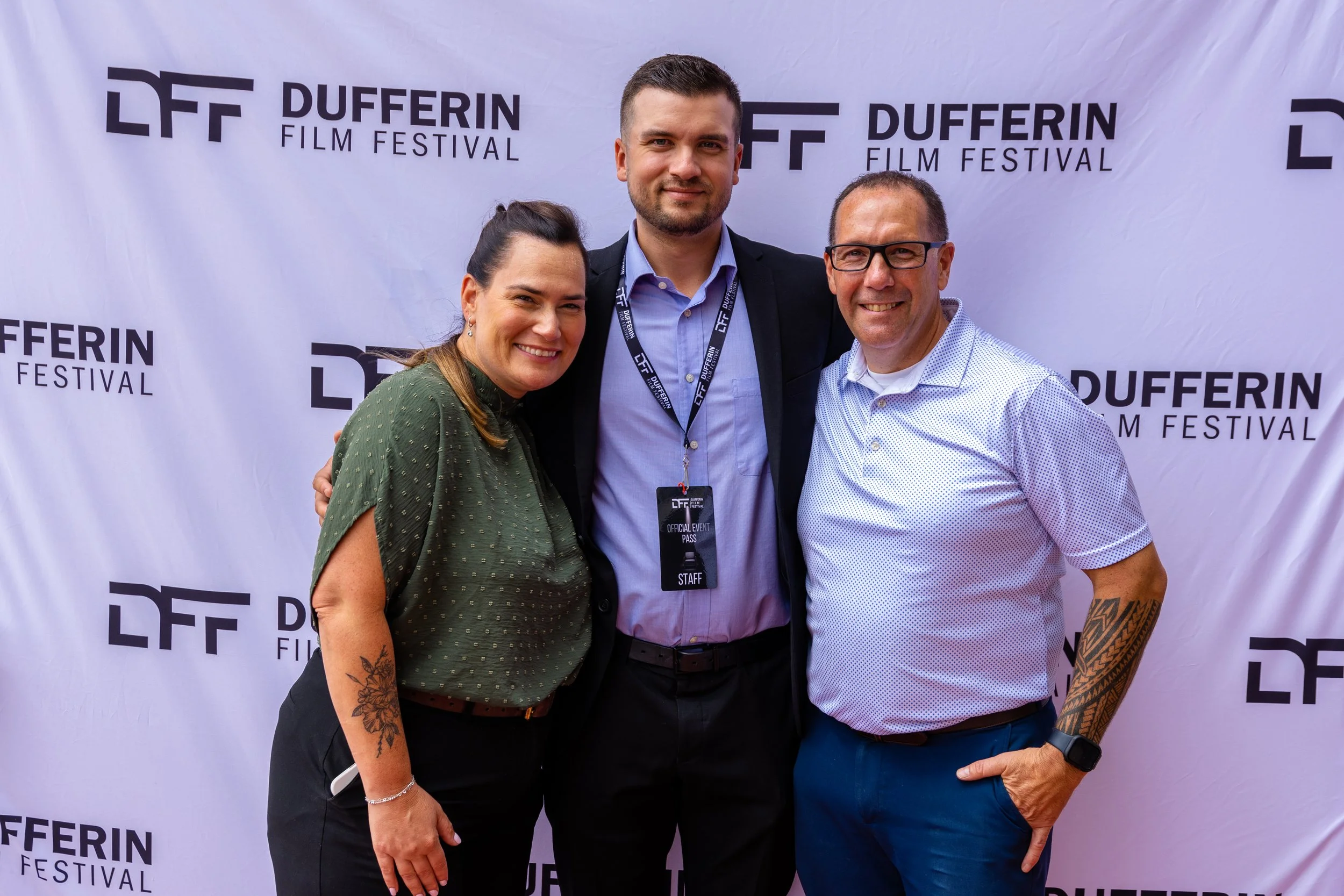 Three people smiling in front of a "Dufferin Film Festival" backdrop.