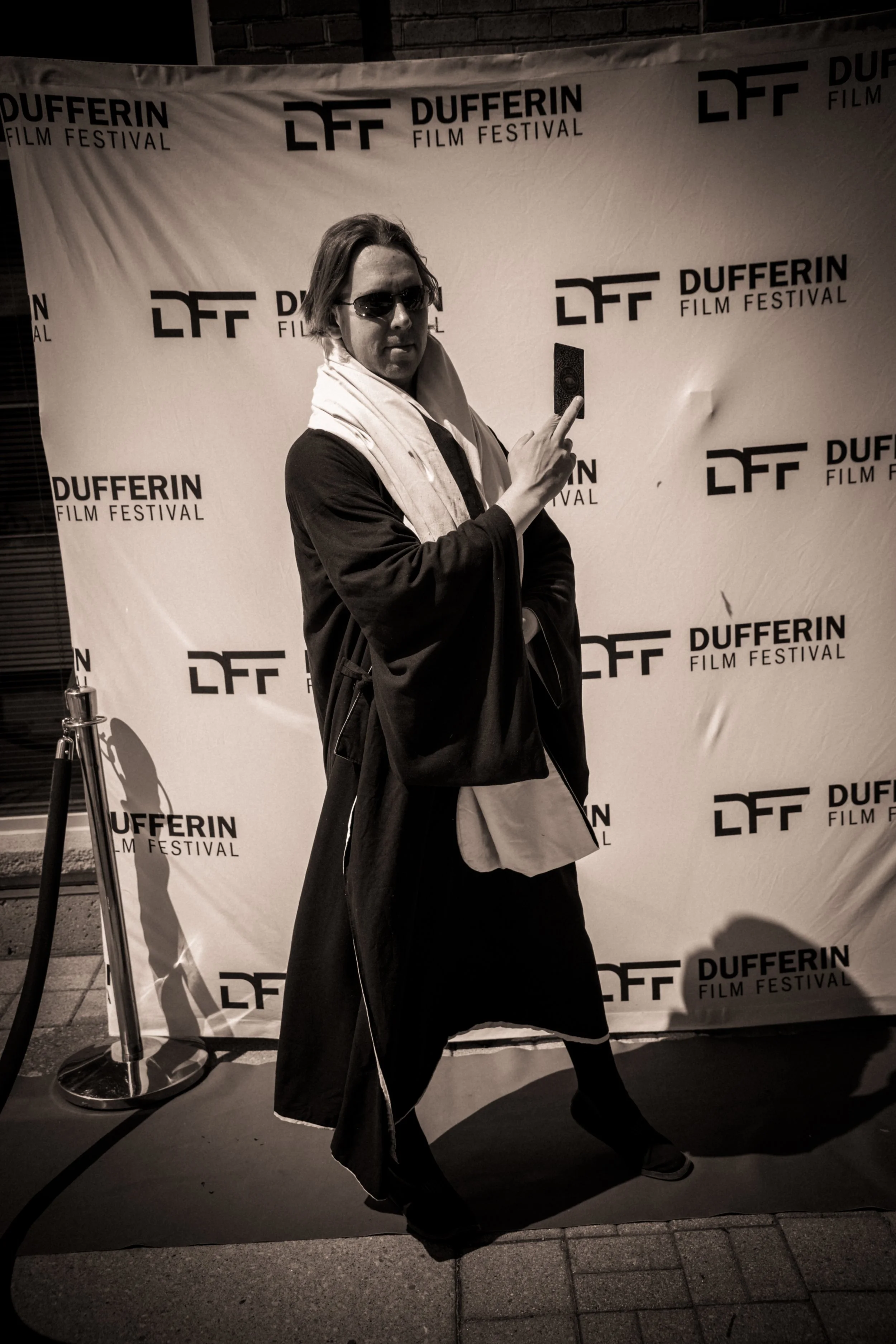 Person in costume with sunglasses posing on the red carpet of Dufferin Film Festival.