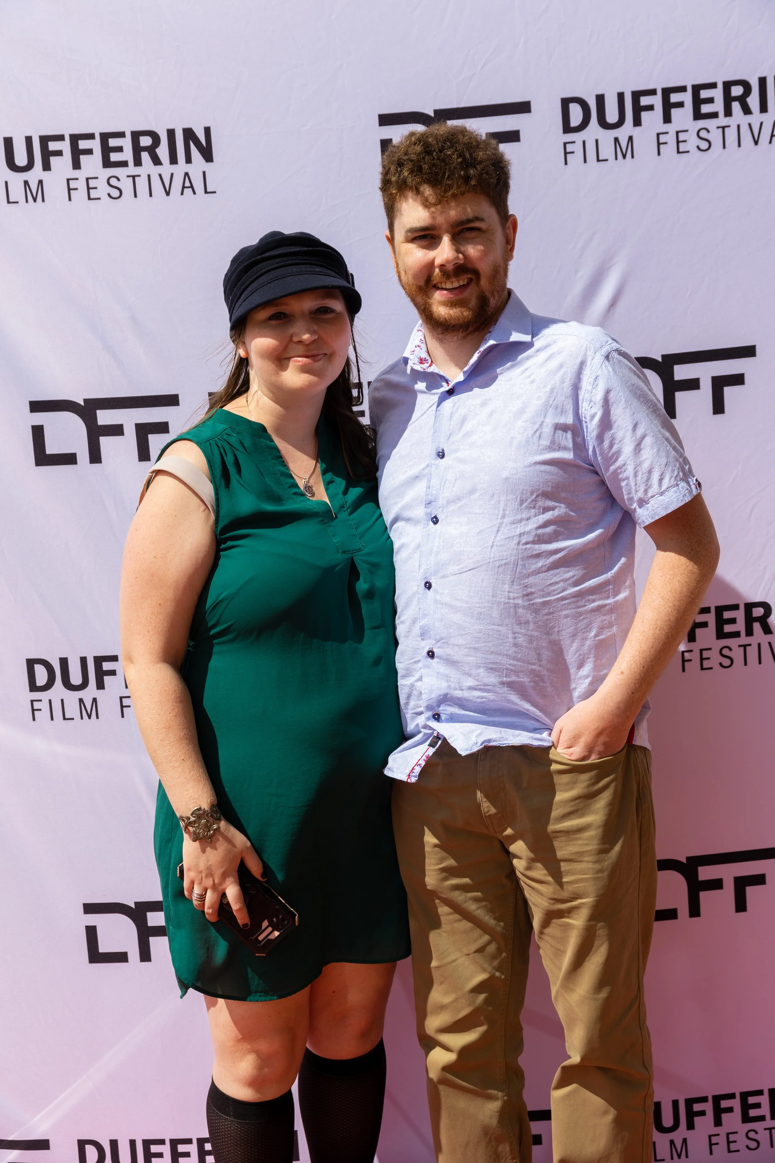 Two people posing in front of a Dufferin Film Festival backdrop.