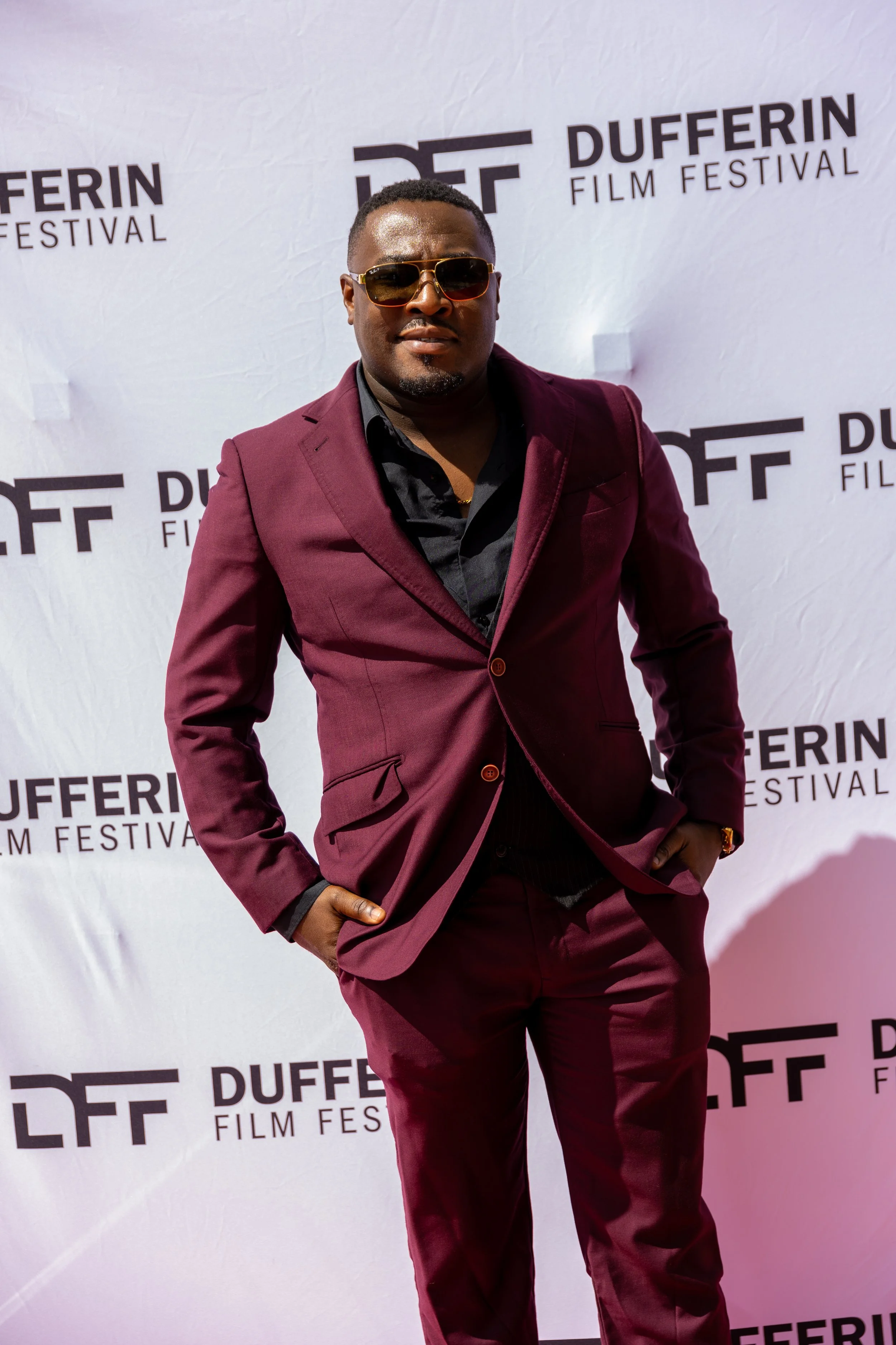 Man in maroon suit with sunglasses at Dufferin Film Festival event.